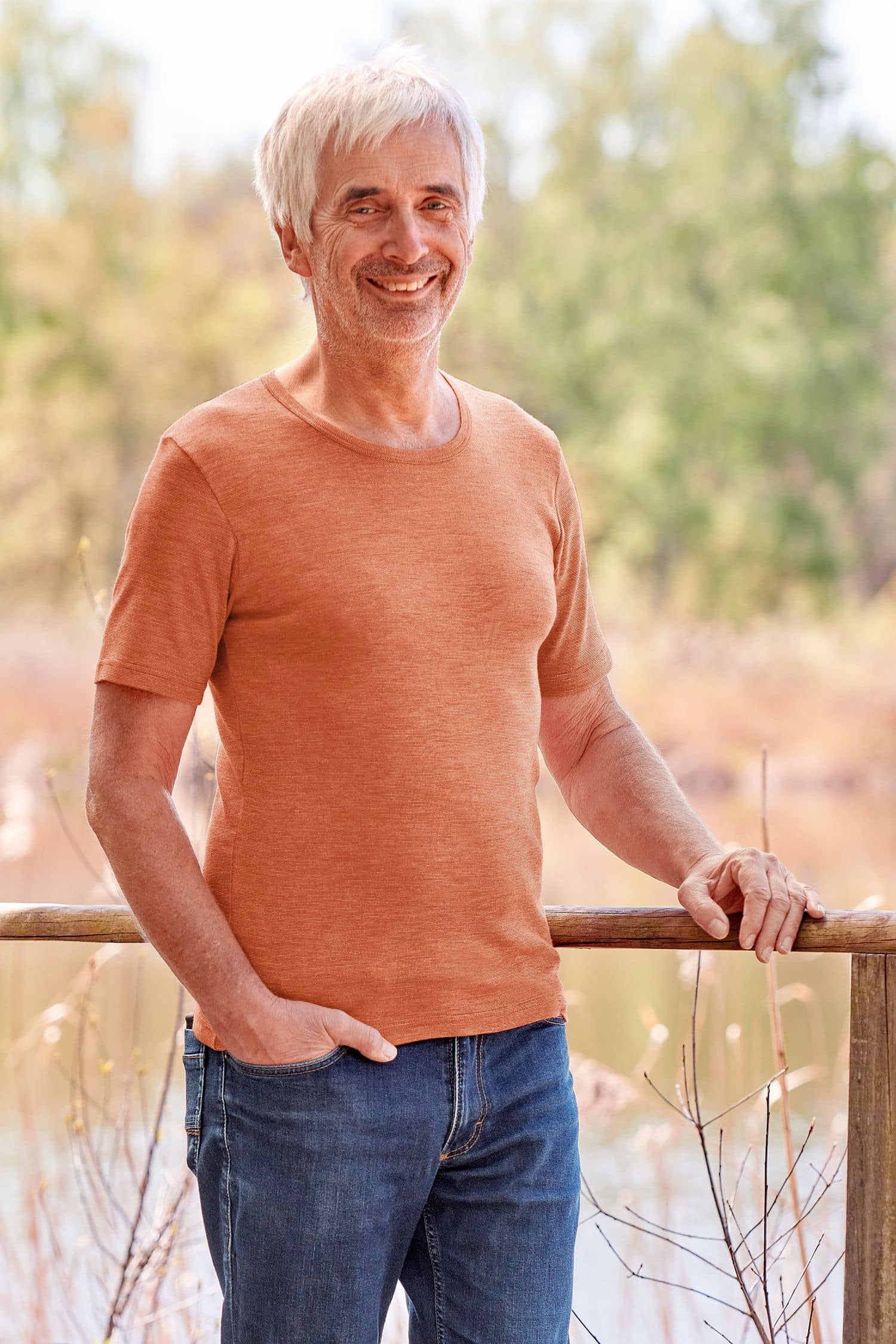 Baumwolle-Wolle-Seide Herren-Kurzarmshirt mit Bio-Fasern Mann trägt oranges Kurzarmshirt aus bio Wolle (kbT), bio Baumwolle (kbA) und Seide