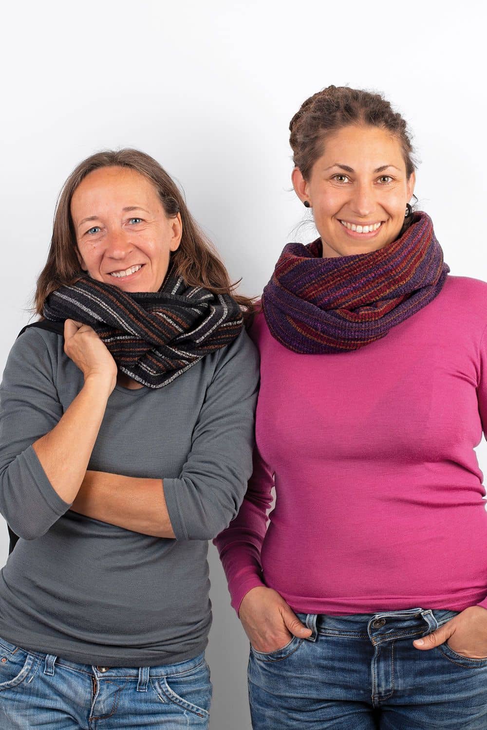 Frauen mit unifarbenen Shirts und Jeans tragen dunkle Loopschals mit Streifenkreppoptik