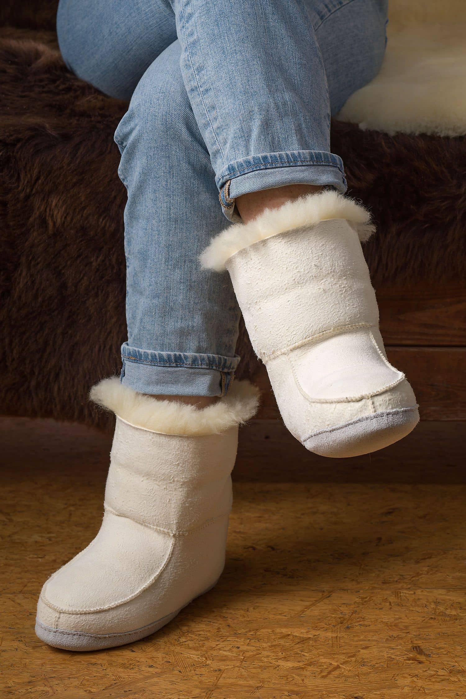 Person trägt relugan gegerbte Fellschuhe aus Schaffell und Rindsleder vom Finbkhof, darunter ein braunes Fell