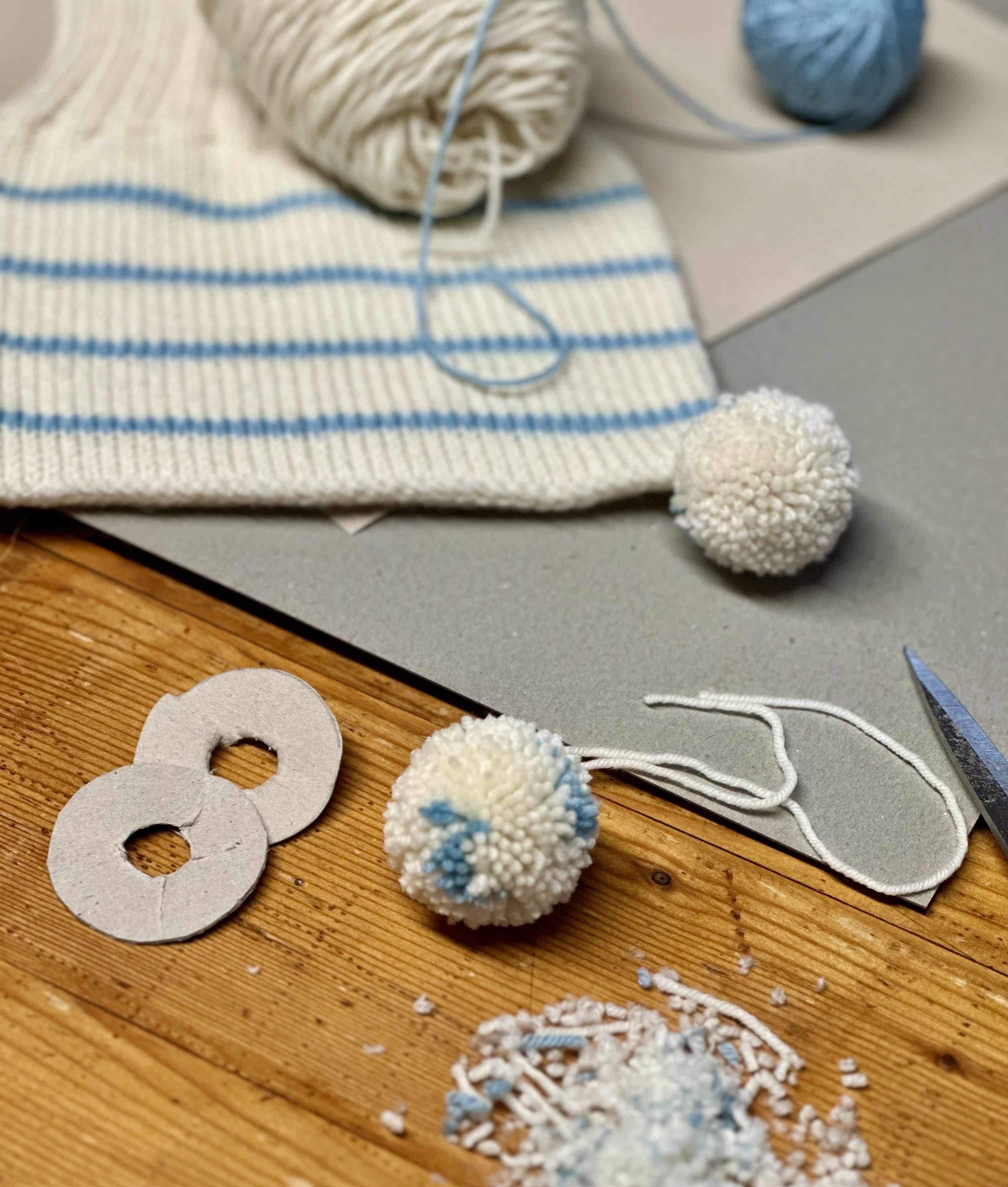 Bommel aus Wolle für weiß blaue Mütze mit weiteren Utensilien