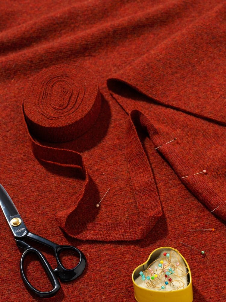 Finkhof-Web-Einfassband gefärbt siena rotes Einfassband aus bio Wolle (kbT) vom Finkhof auf Stimmungsbild mit Nähutensilien