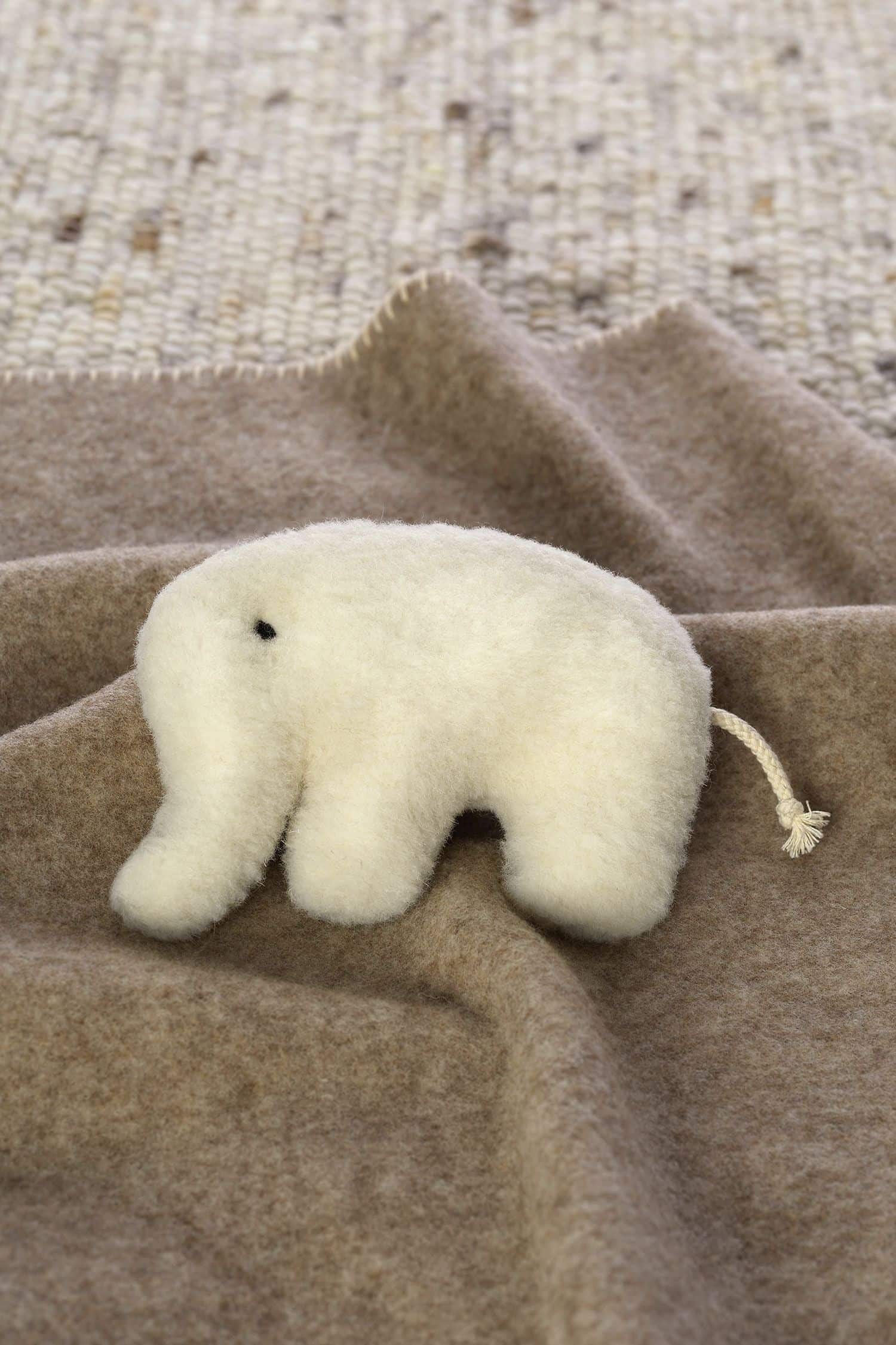 weißer Rasselelefant auf brauner Wollldecke