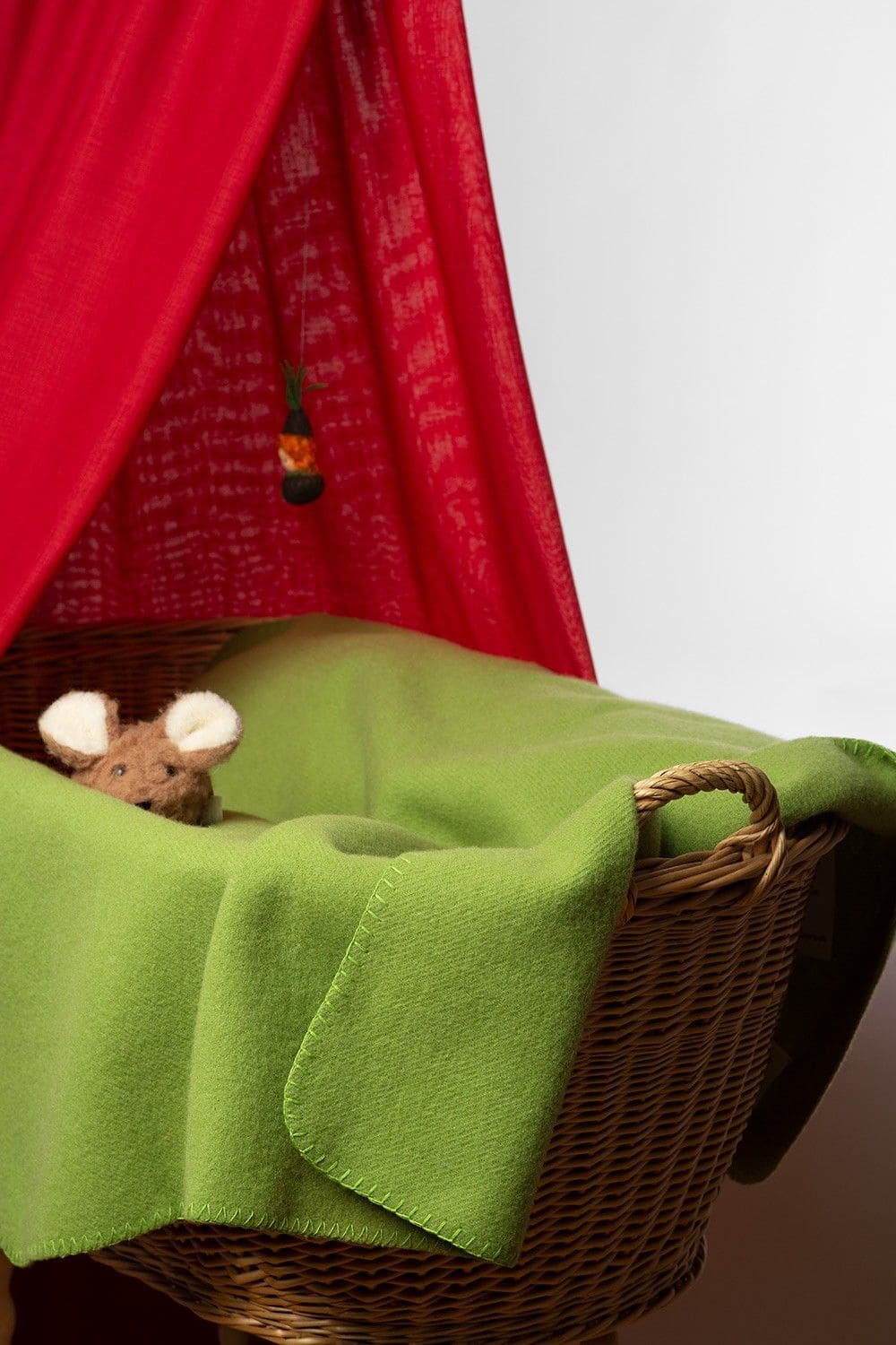 hellgrüne Kinder Wolldecke aus bio Wolle (kbT) vom Finkhof liegt in einem Stubenwagen
