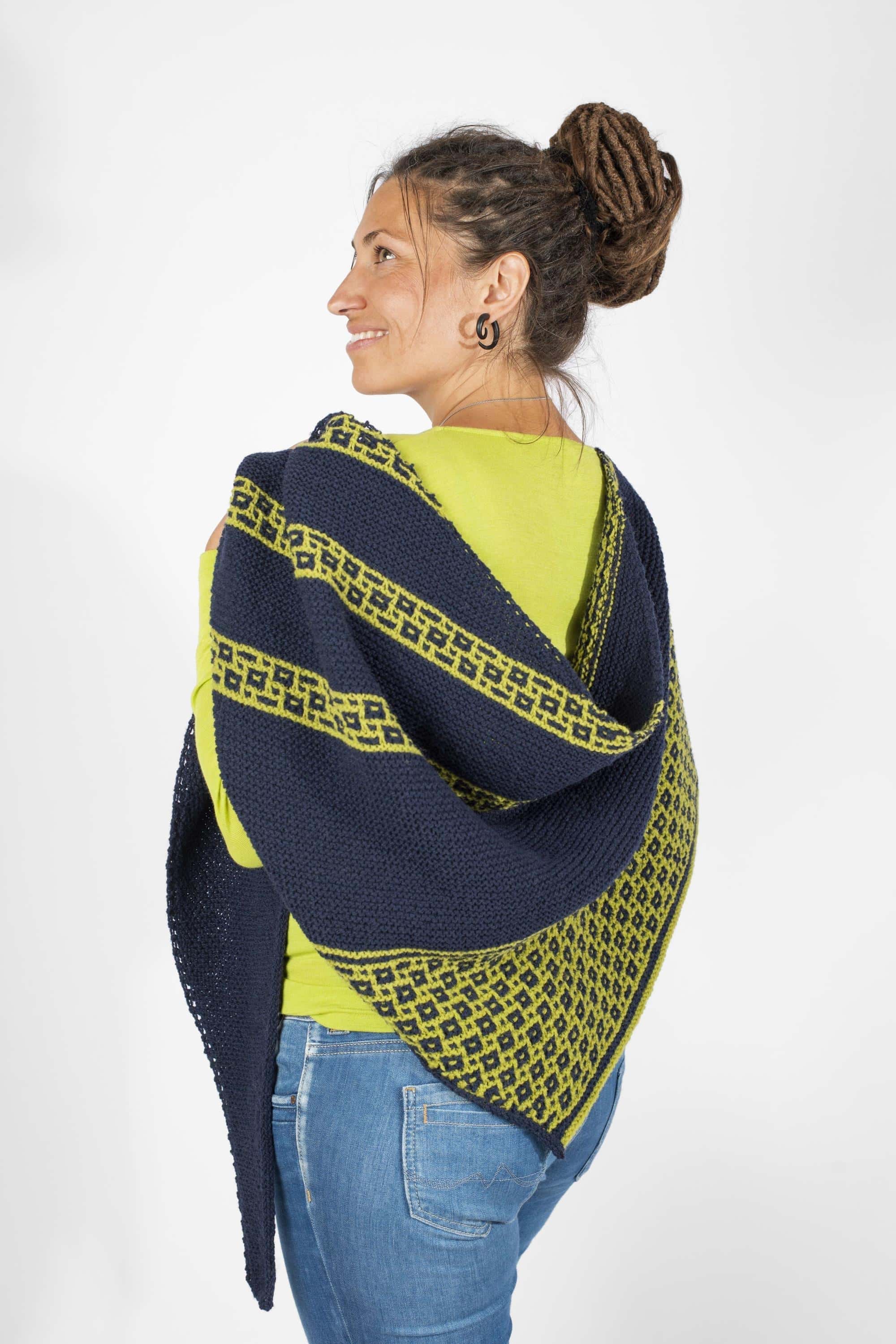 Frau mit grünem Shirt legt sich blau grünen Schal als Beispielprojekt für das Buch ,,Colorwork Shawls" über die Schulter