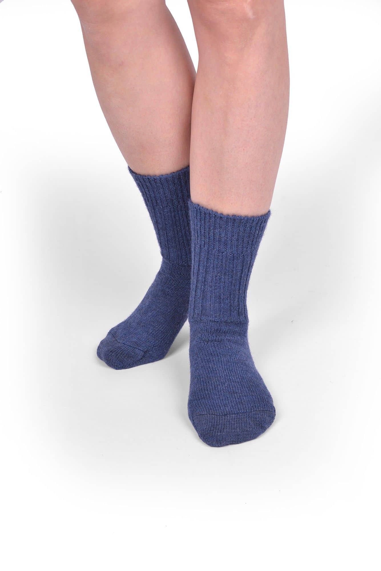 Person trägt jeansblaue Wollsocken aus bio Wolle (kbT) in mittlerer Dicke, von vorne