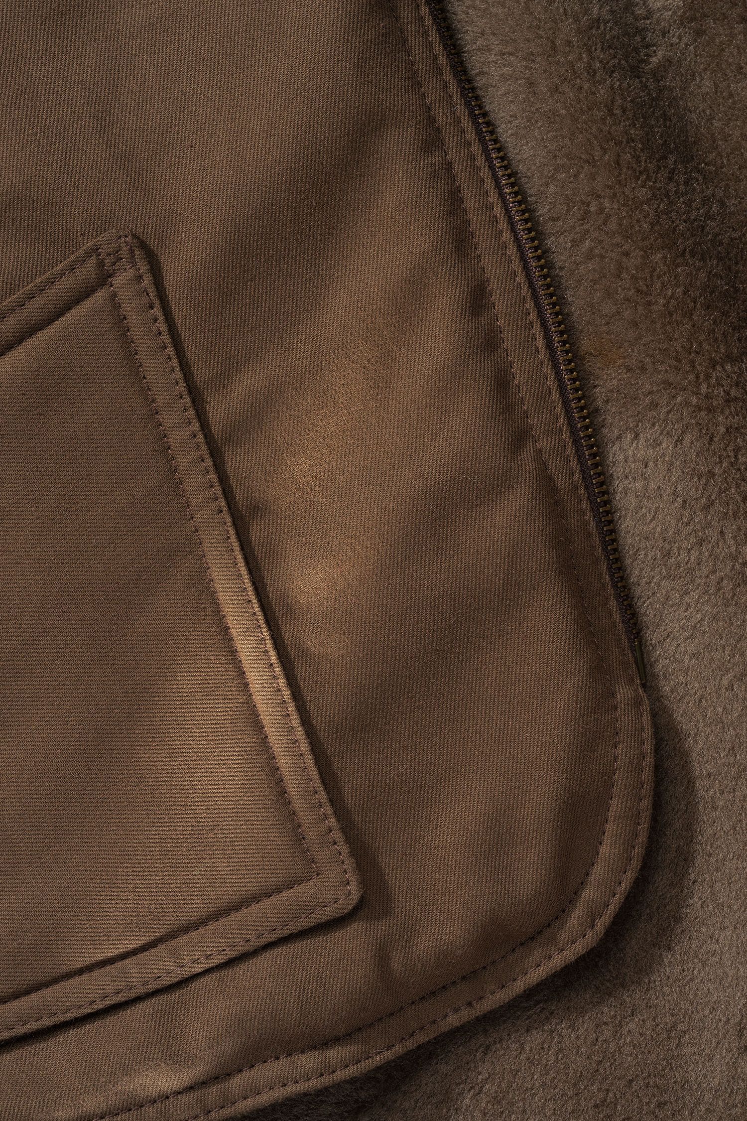 Detailaufnahme der braunen Fellweste aus bio Baumwolle (kbA) und Fell vom Finkhof