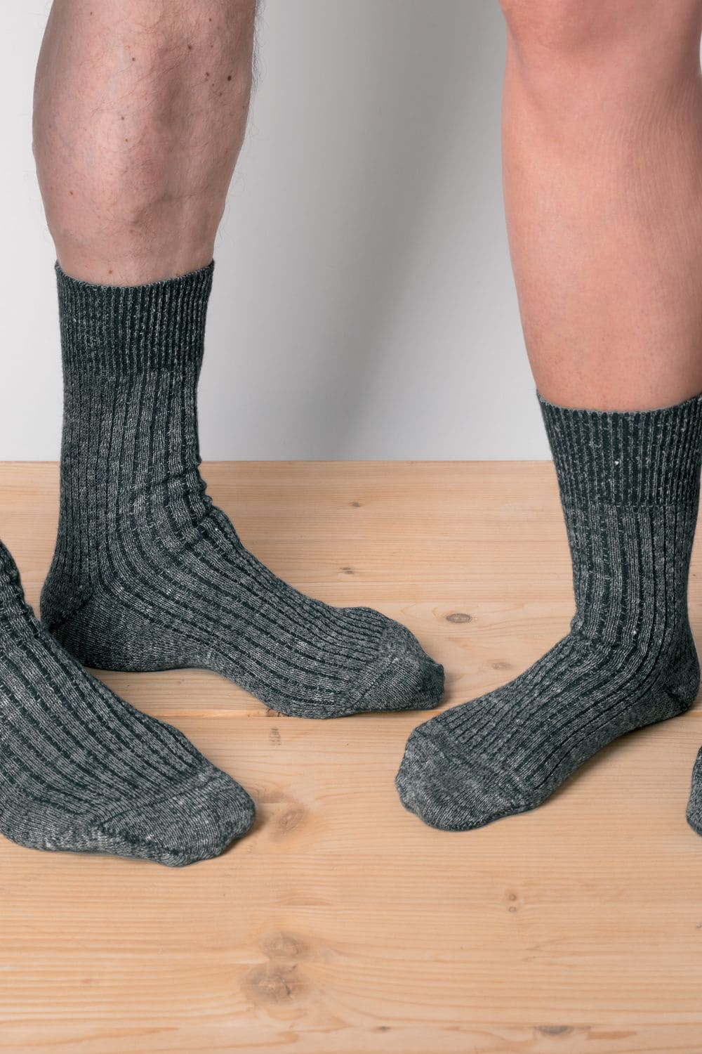 graumelierte bio Wolle (kbT)-Leinen- Socken getragen von 2 Menschen mit nacktem Bein im Stehen