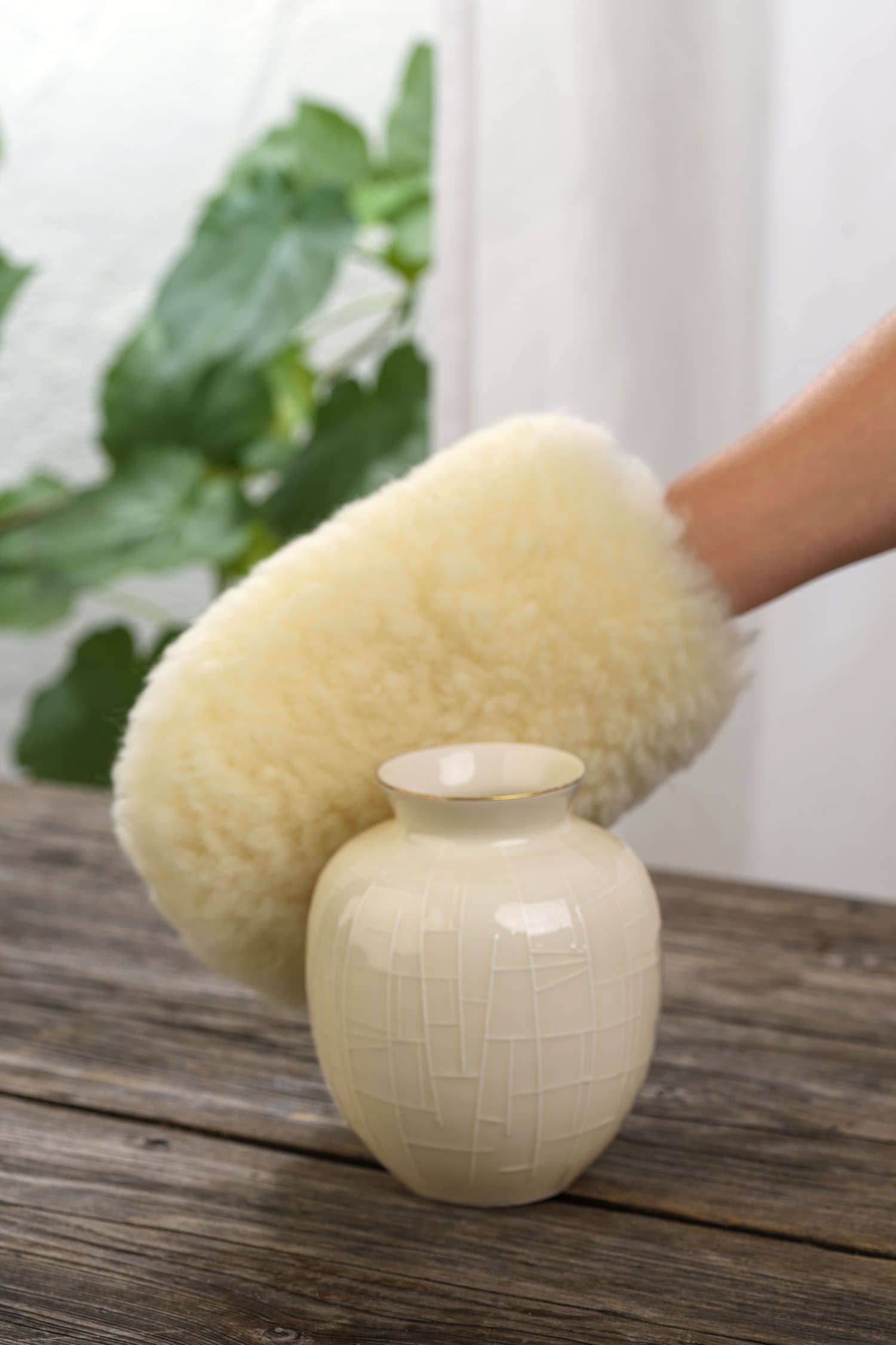 gelblicher Staubhandschuh vom Finkhof aus relugan gegerbtem Schaffell beim Putzen einer Vase