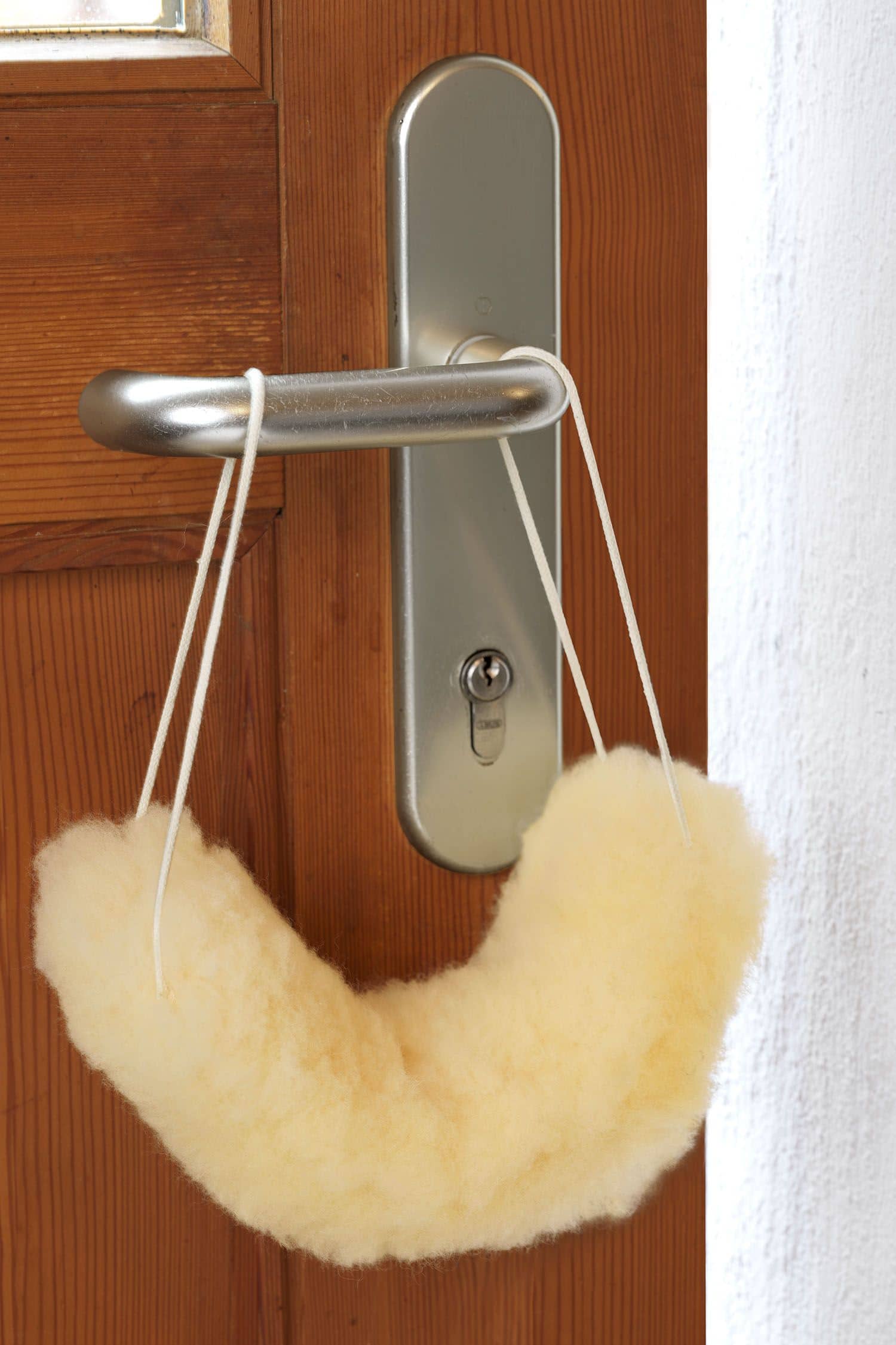 gelblicher Türstopper für die Türklinke aus relugan gegerbtem Schaffell vom Finkhof, hängt an einer Türklinke