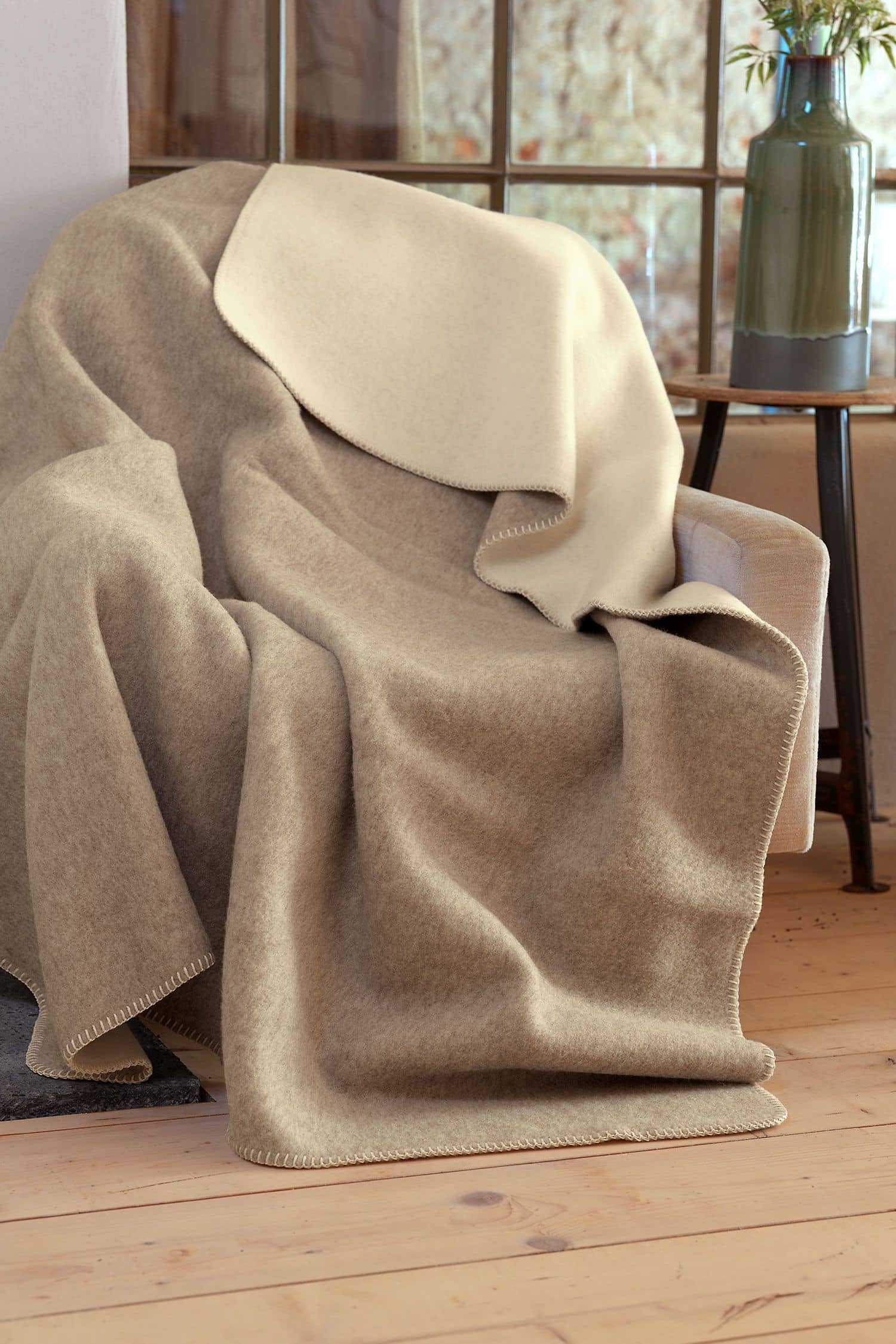 Wolldecke naturweiß/beige weiß beige Wolldecke auf grauem Sessel