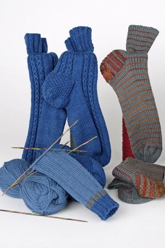 feine Finkhof Sockenwolle in blau und grau auf Stimmungsbild mit Stricksocken und Nadelspiel