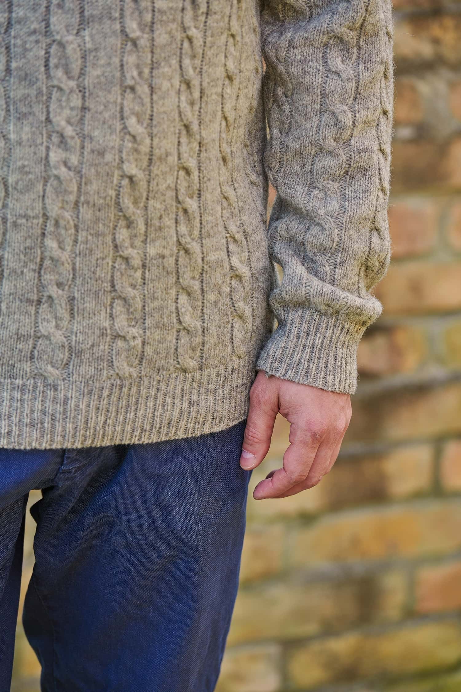 Detailaufnahme der Bündchen des grauen Strickpullover mit Zopfmuster aus Bio-Schurwolle vom Finkhof