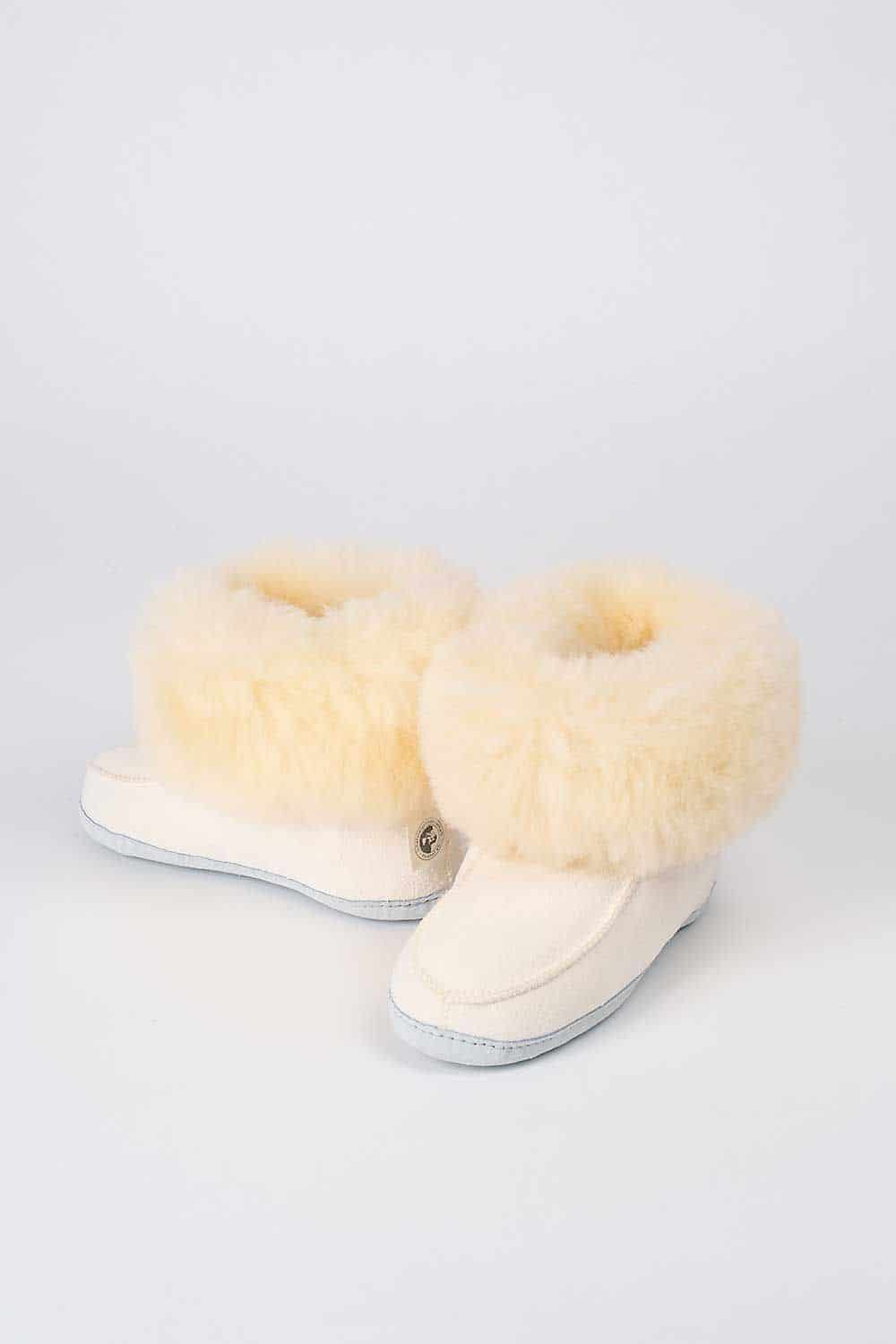 Ein Paar weiße Finkhof Fellschuhe aus Schaffell und Rindsleder, ein Schuh zeigt nach vorne und der Andere zur Seite