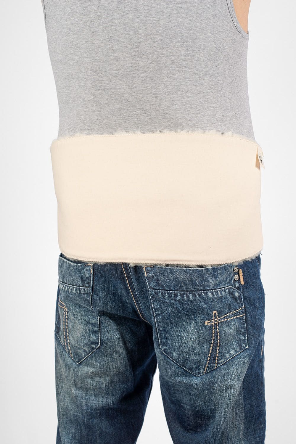 Mann von hinten mit Top, Jeans und weißem relugan gegerbtem Finkhof Rückenwärmer aus Schaffell und bio Baumwolle (kbA)