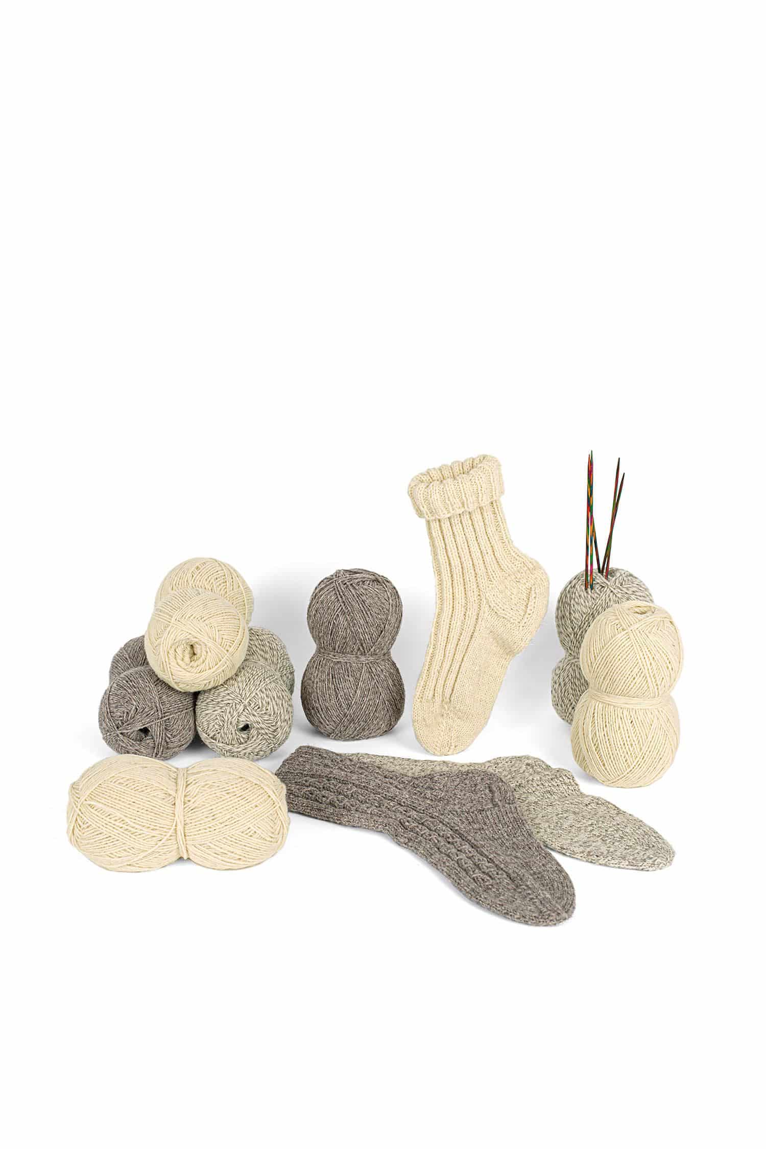 Finkhof Sockenwolle ungefärbt dreifädiges Finkhof Sockengarn aus bio Wolle (kbT) ungefärbt, Wollknäule, gestrickte Socken und Stricknadeln