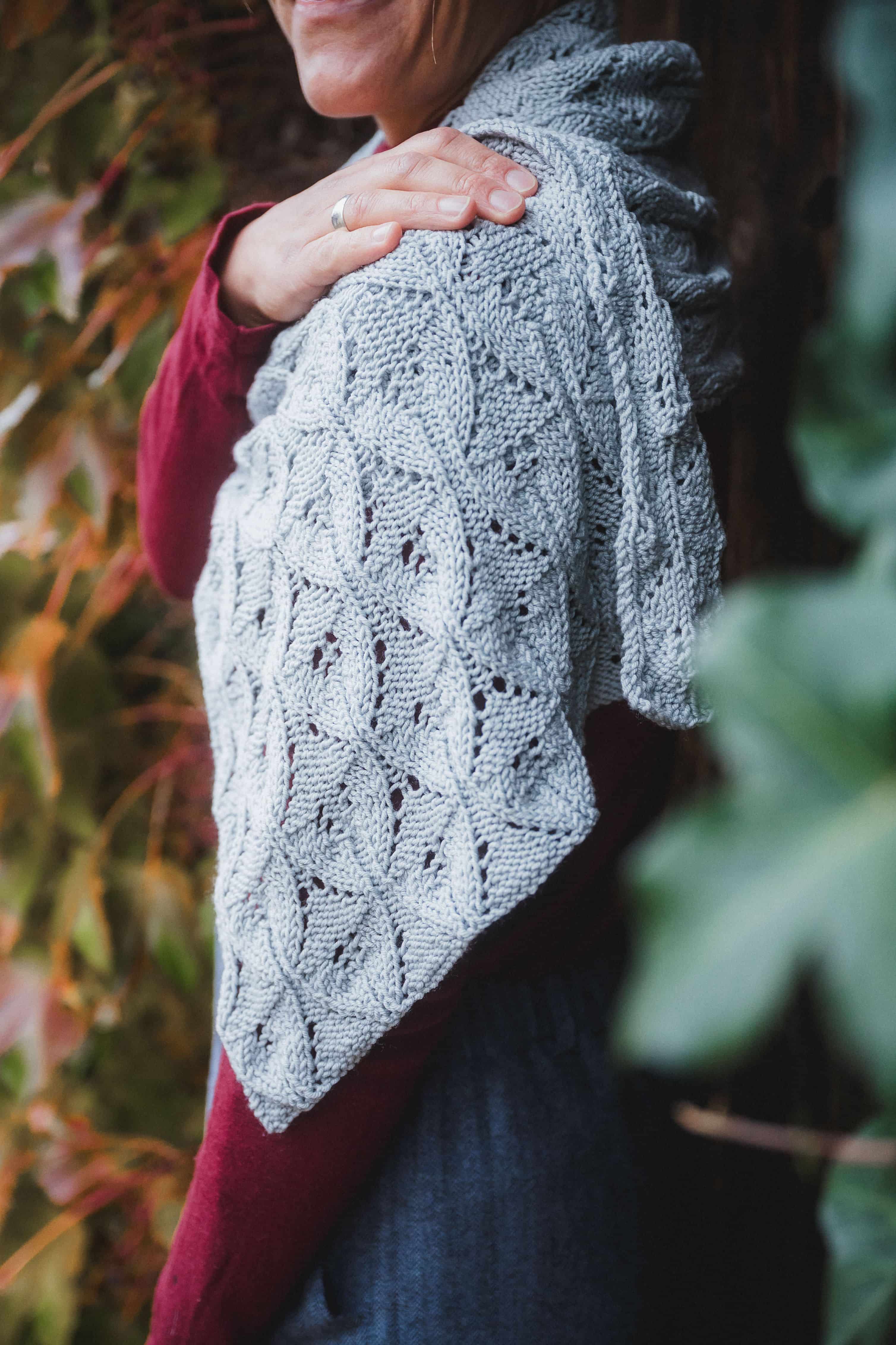 Frau mit rotem Shirt hat blauen Schal mit Ajourmuster über Schultern gelegt