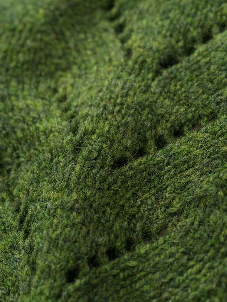 Nahaufnahme der Struktur des grünen Strickpullunder aus Bio-Wolle vom Finkhof