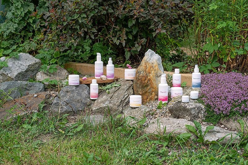 Naturkosmetik mit Lanolin vom Finkhof verschiedene Finkhof Kosmetikprodukte sind in Steinen verteilt