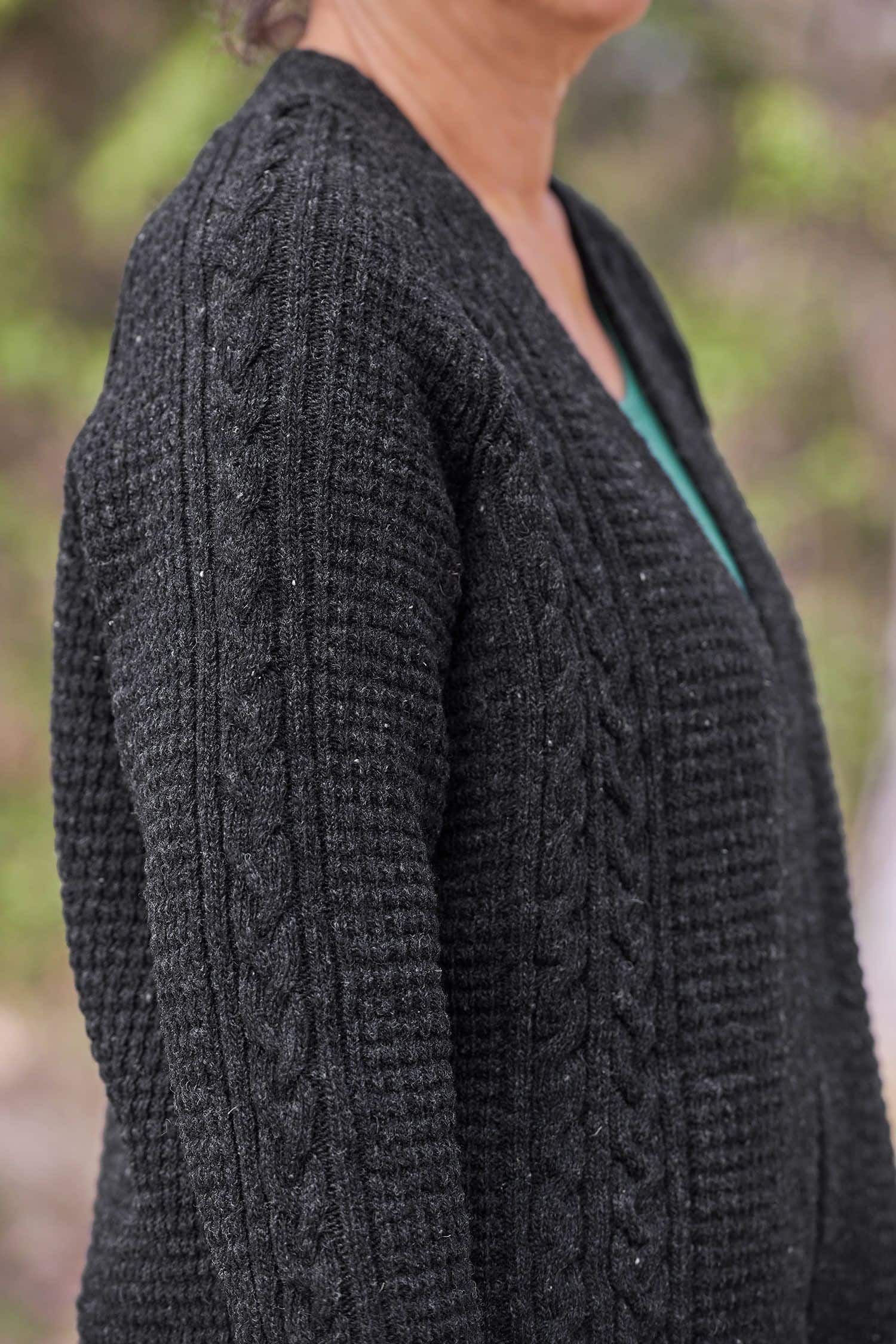 Nahaufnahme vom Zopfmuster des anthrazitfarbenen Cardigan vom Finkhof aus bio Wolle (kbT)