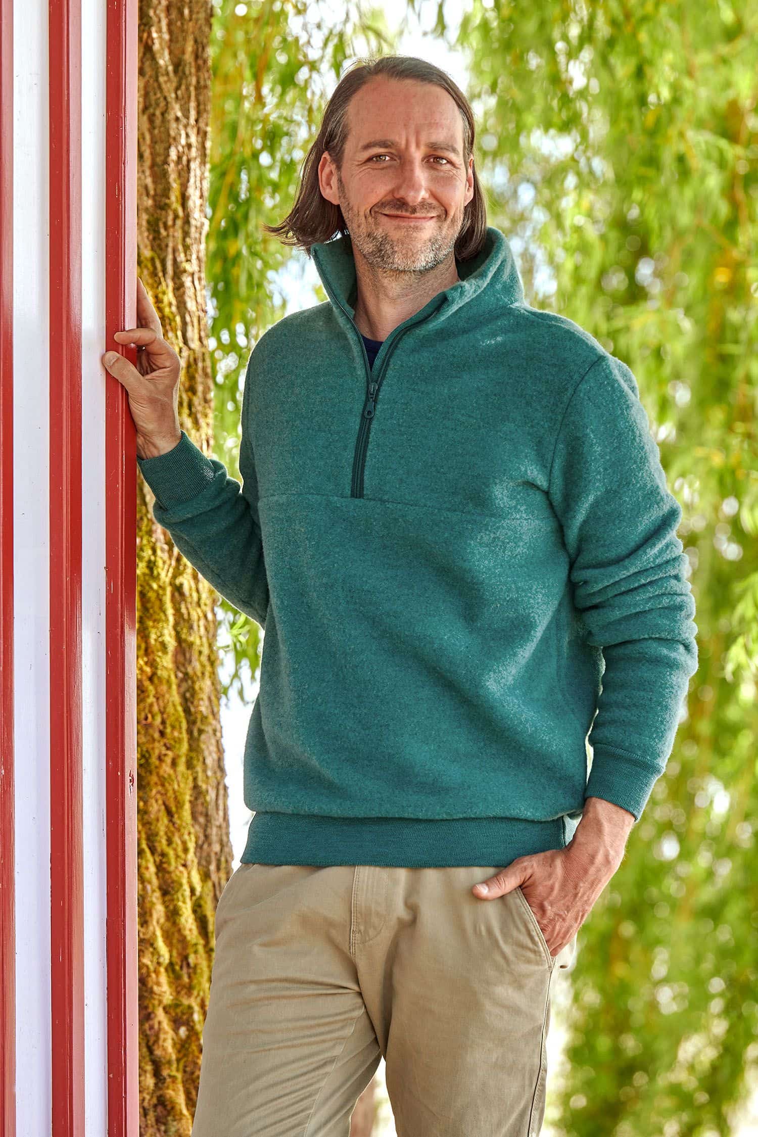 Mann trägt türkisen Wollfleece Pullover mit Reißverschluss aus bio Wolle (kbT) vom Finkhof