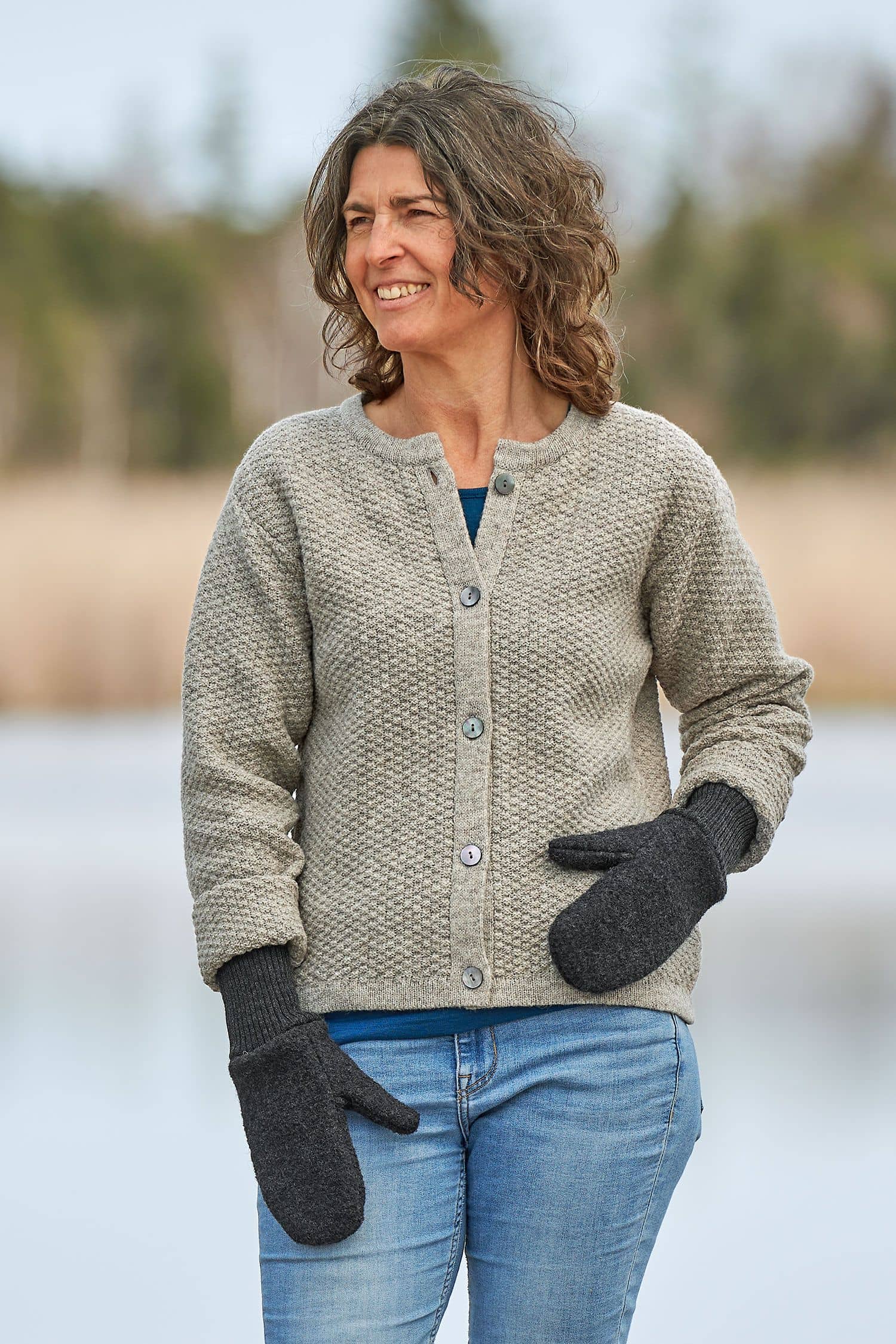 Frau mit grauem Cardigan trägt anthrazitfarbene Walkfäustlinge aus bio Wolle (kbT) vom Finkhof