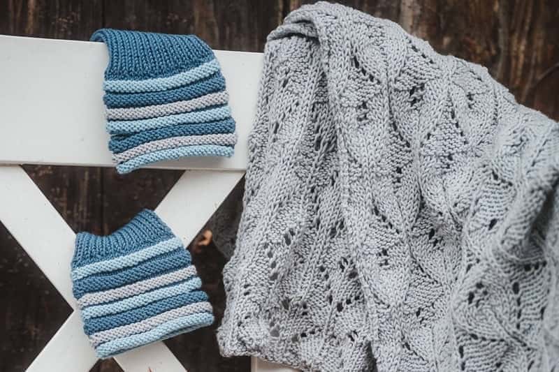 auf einer Bank liegt ein Schal mit Ajourmuster und selbstgestrickte Stulpen aus Finkhof Wolle