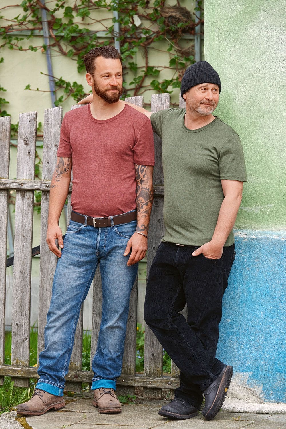 Wolle-Seide Herren T-Shirt Männer tragen grünes und rotes kurzarm Shirt aus bio Wolle (kbT) und Seide mit Jeans, einer trägt eine Mütze