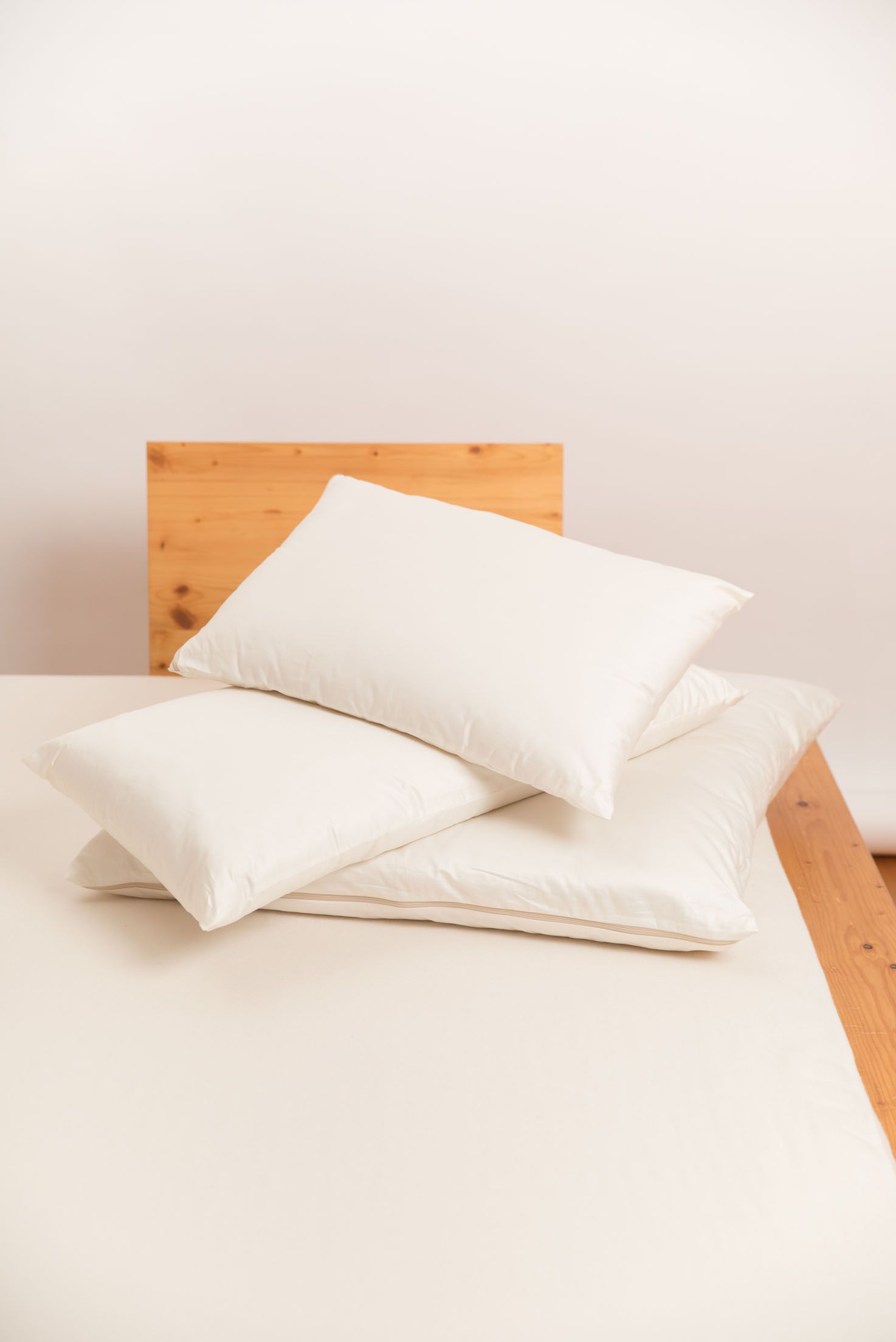 Kopfkissen und Decke auf braunem Holzbett