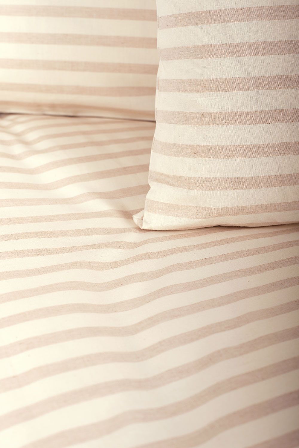 Nahaufnahme von ungefärbter Bettwäsche mit Streifen aus bio Baumwolle (kbA) als Decken- und Kissenüberzug