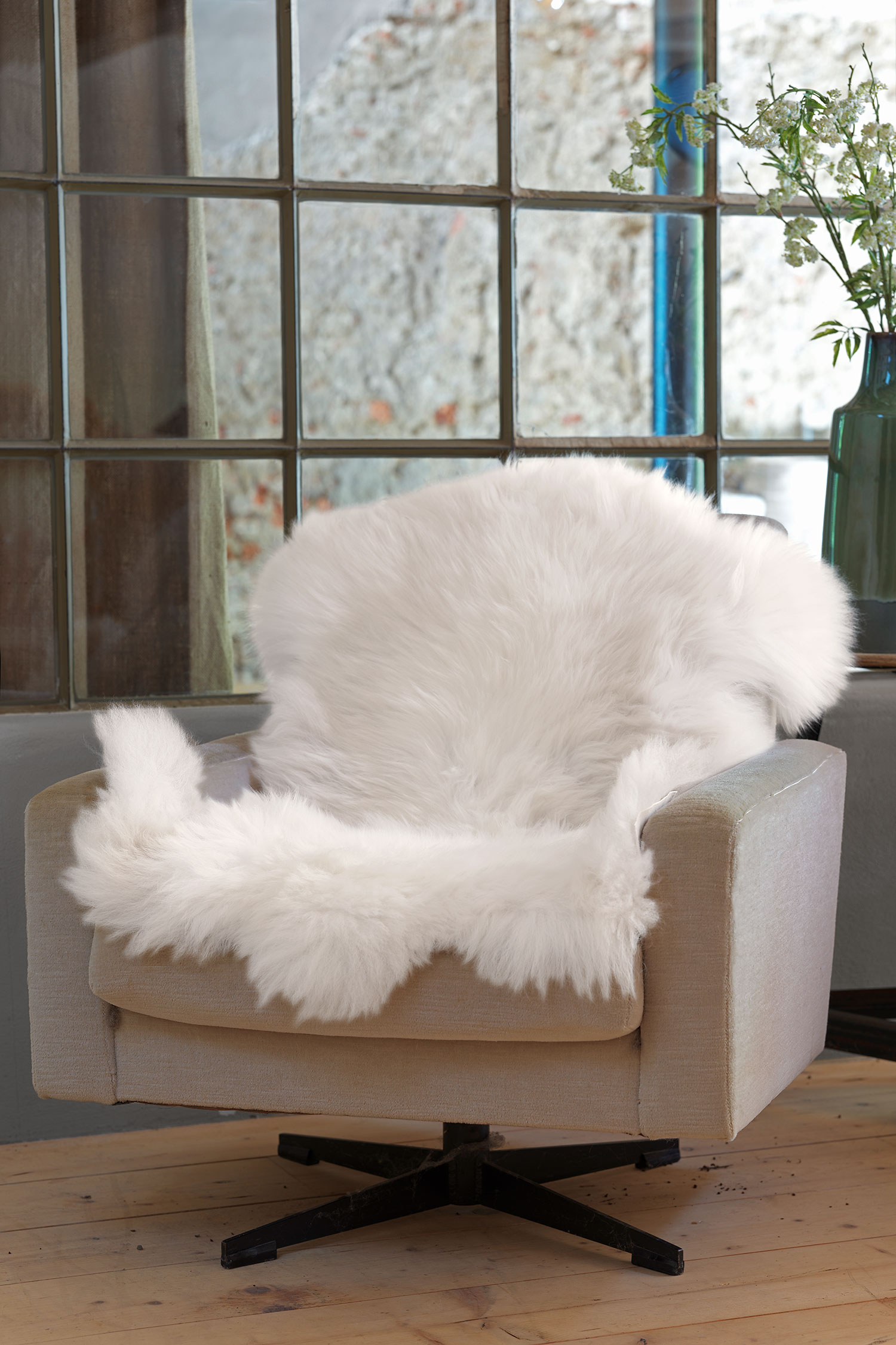 weißes langhaariges pflanzlich gegerbtes Schaffell vom Finkhof auf beigem Sessel