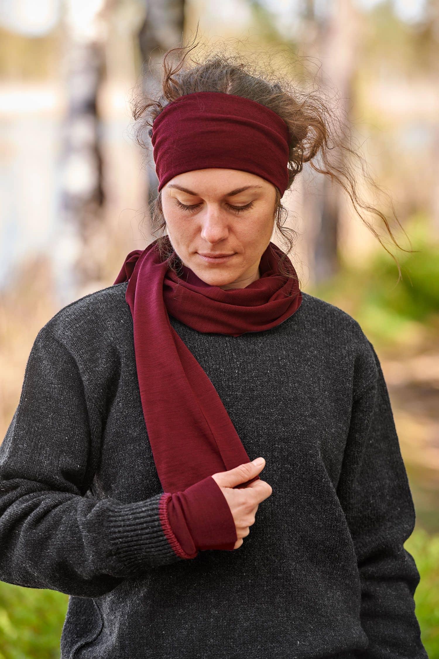 Frau trägt bordeauxfarbener Wolle Seide Schal aus bio Wolle (kbT) mit passendem Stirnband und grauem Strickpulli