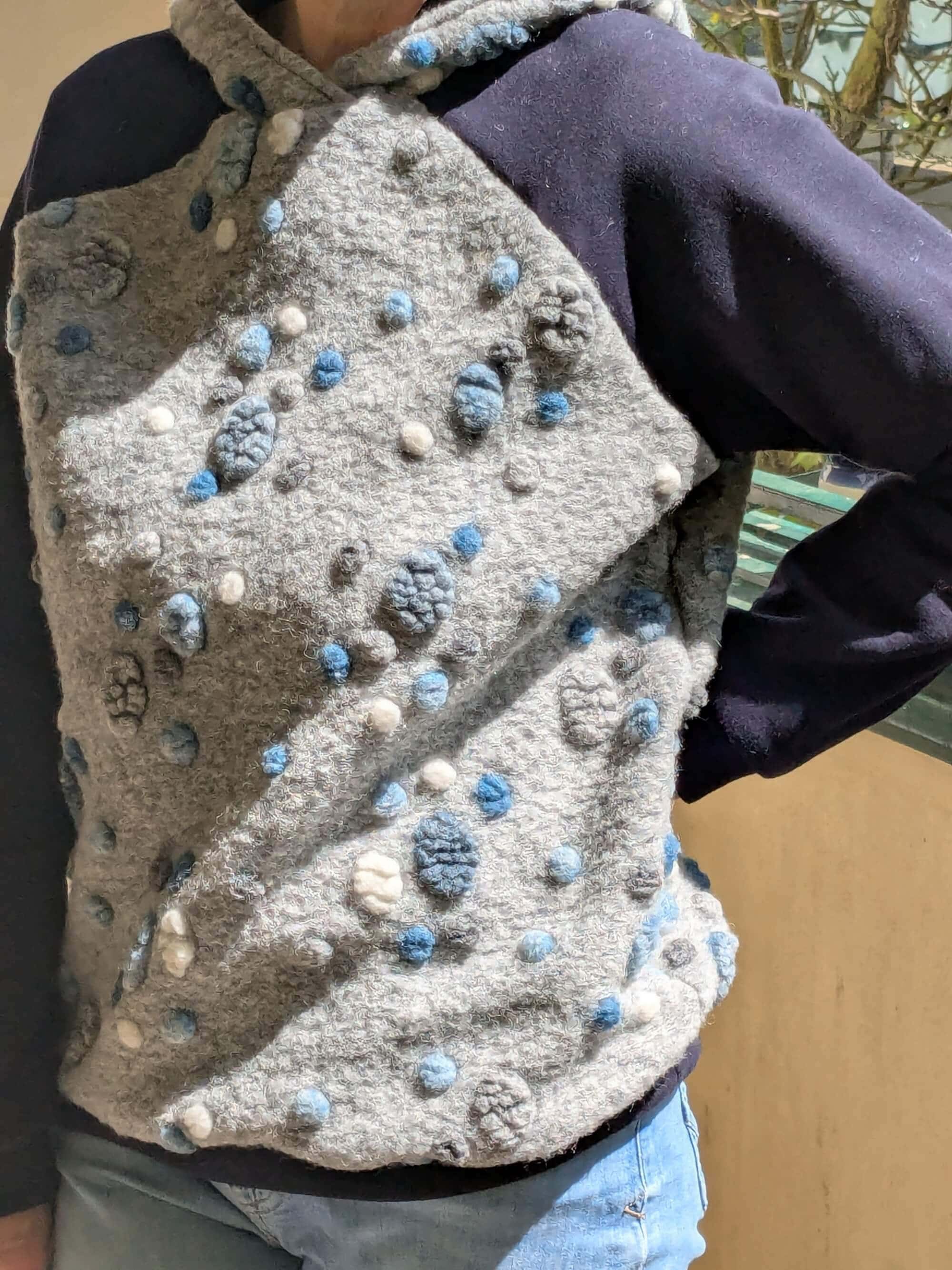 Hoodie aus blau grauem Musterwalk mit Punkten, getragen seitlich von vorne