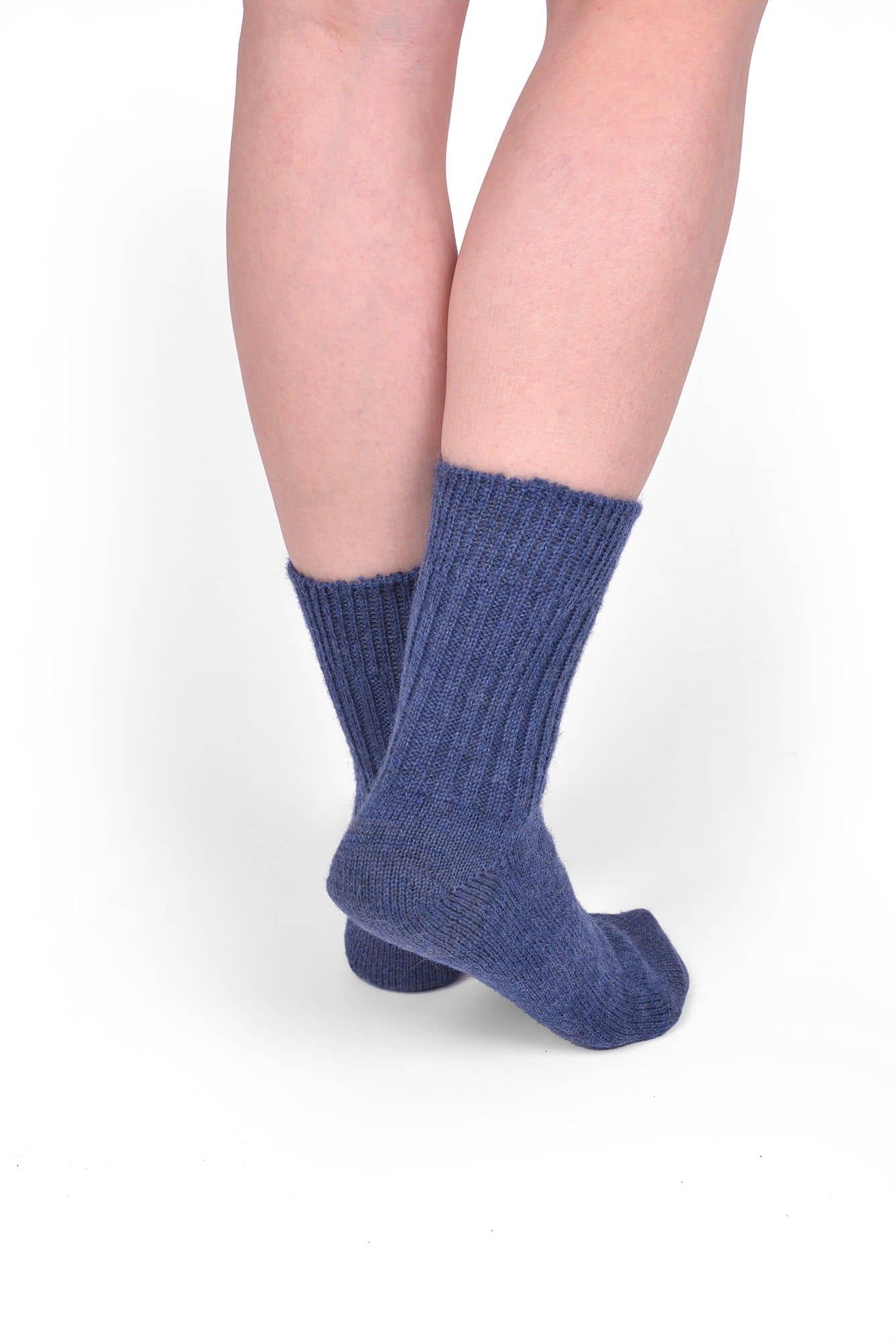 Person trägt jeansblaue Wollsocken aus bio Wolle (kbT) in mittlerer Dicke, von hinten