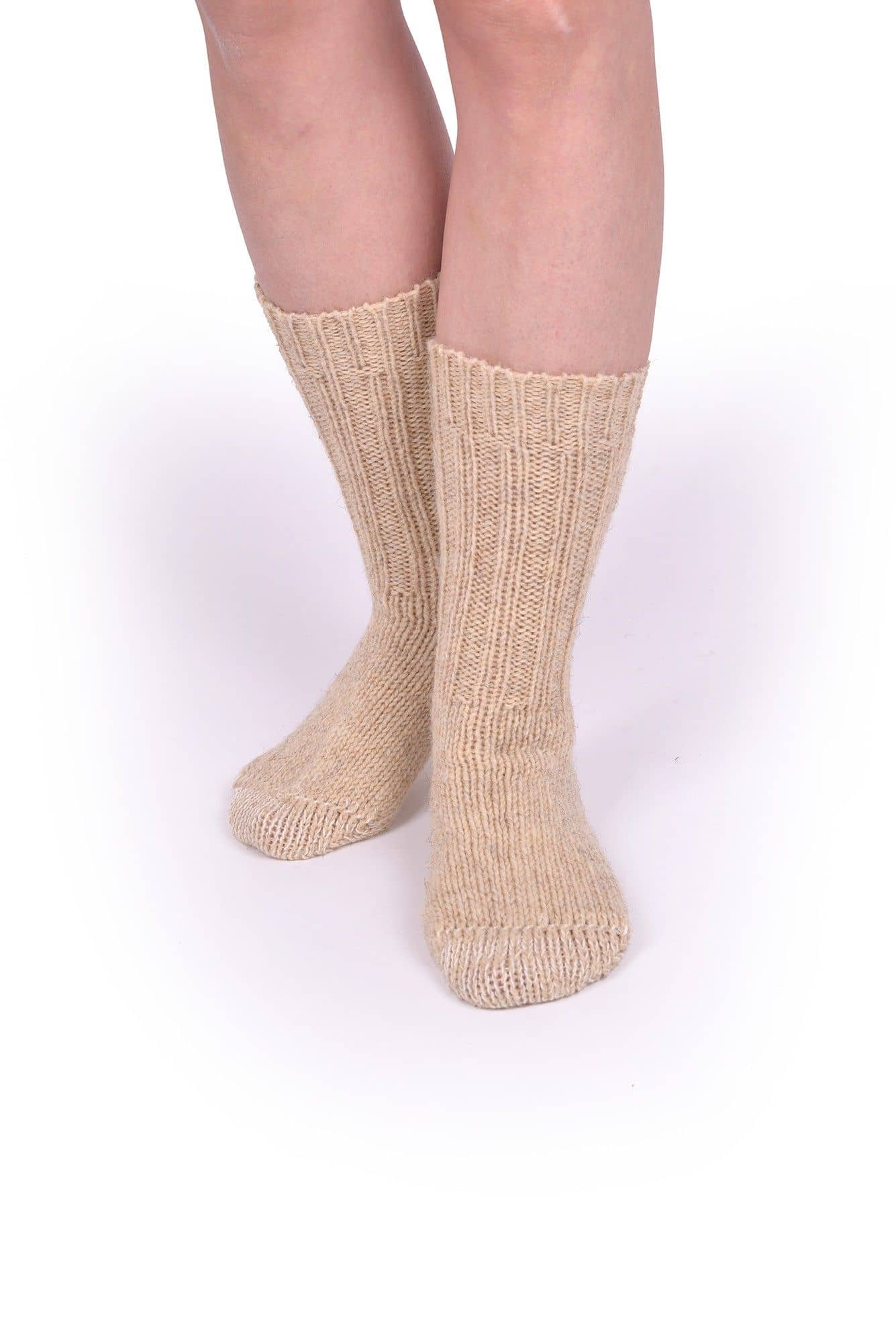 Person trägt beige dicke Finkhof Socken aus bio Wolle (kbT) auf weißem Untergrund von hinten