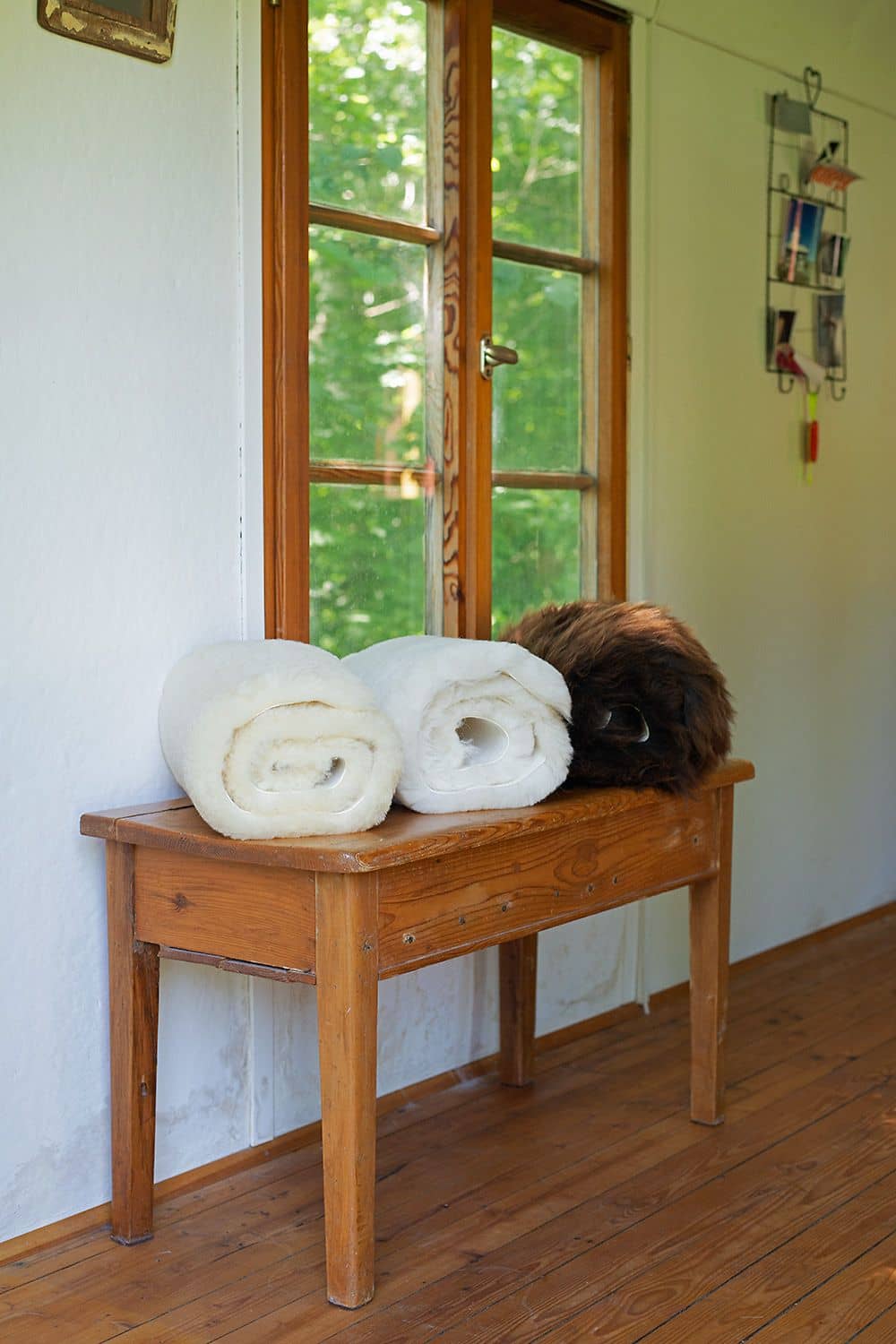 Bankauflage aus Fell 35 x 90 cm Finkhof Bankauflagen aus Schaffell aufgerollt in verschiedenen Farben auf Hockerchen