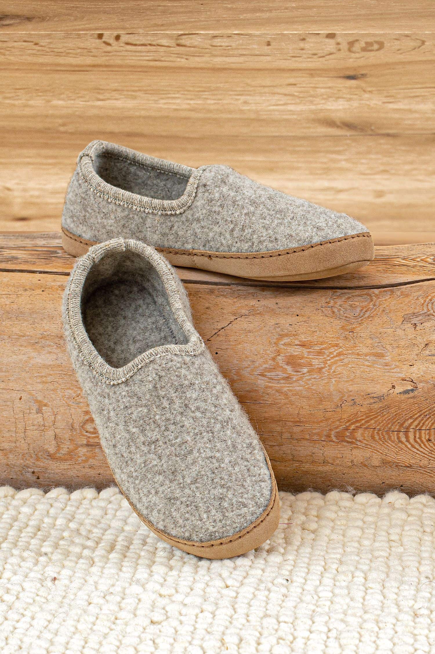 Finkhof-Hausschuhe mit Ledersohle hellgraue Finkhof Hausschuhe aus bio Wolle (kbT) und pflanzlich gegerbtem Leder auf Holzstamm