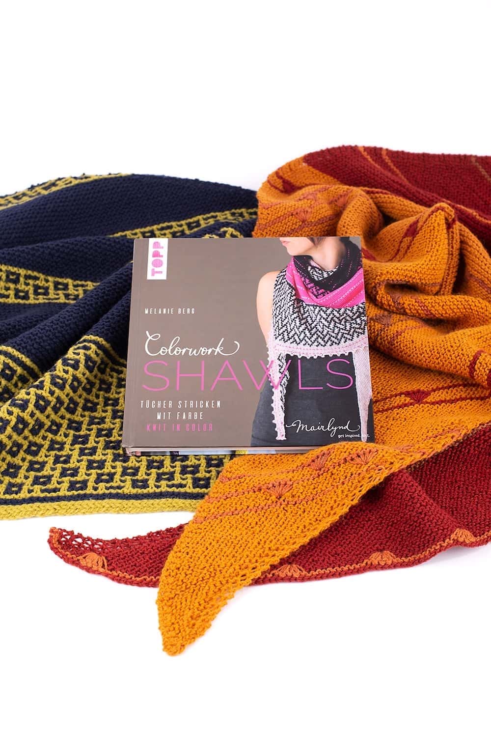 Buch ,,Colorwork Shawls" liegt auf bunten Schals