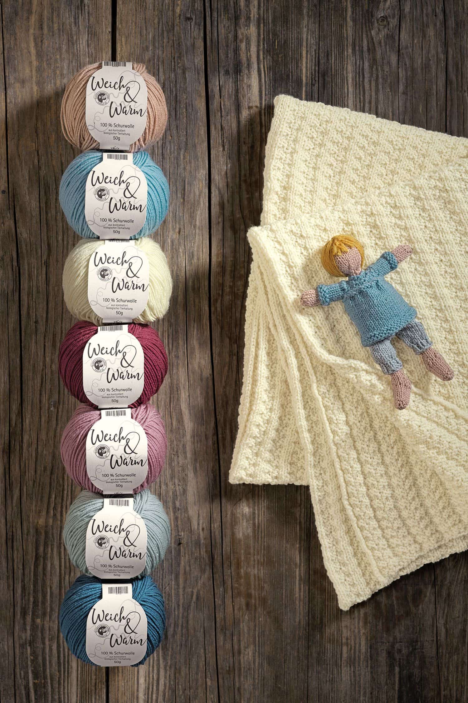 Merinowolle Weich & Warm Finkhof Merinowolle ,,Weich&Warm" aus bio Wolle (kbT) in verschiedenen Farben neben einer Strickpuppe