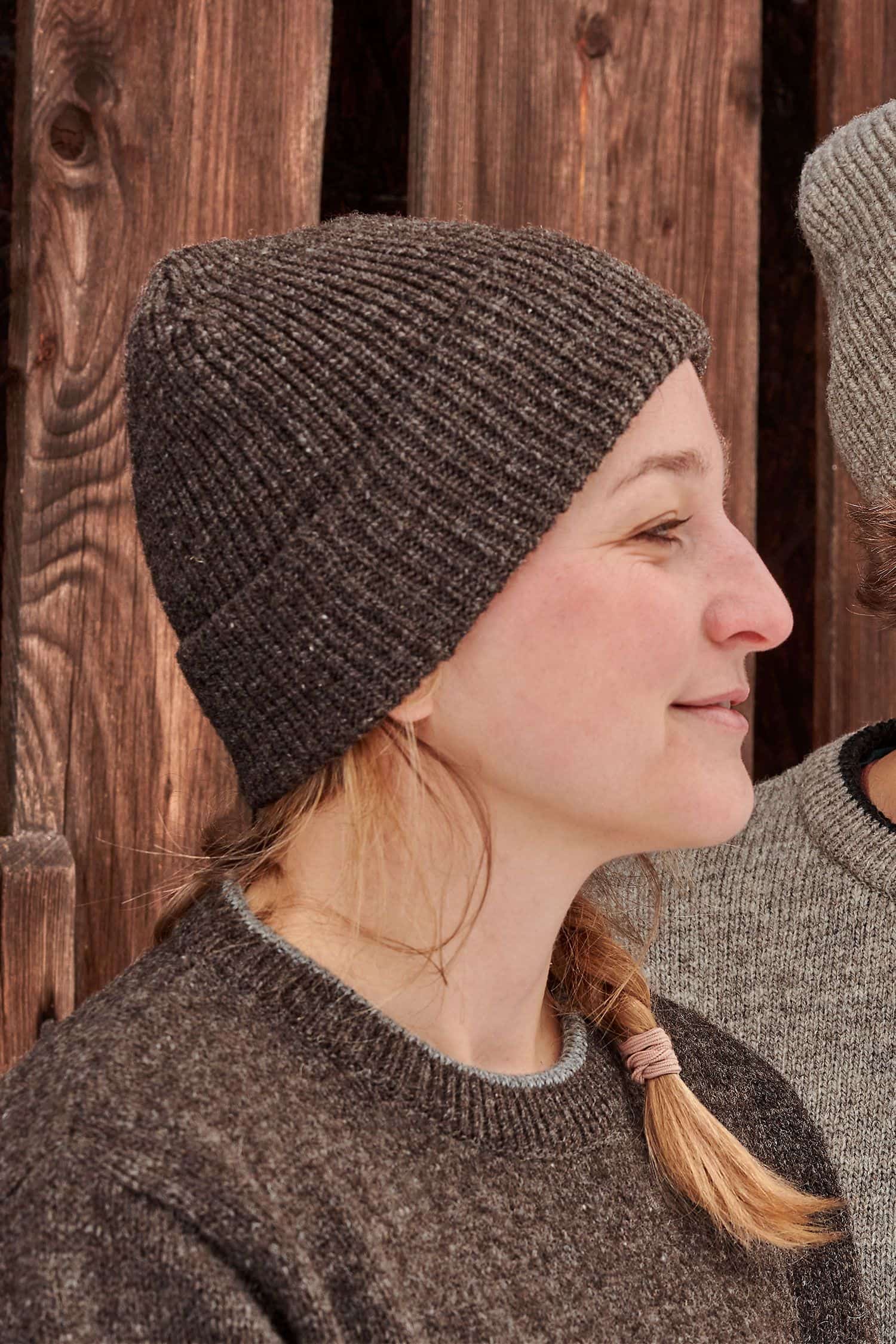 Frau trägt eine braune Finkhof Mütze aus bio Wolle (kbT) und einen braunen Pulli vom Finkhof