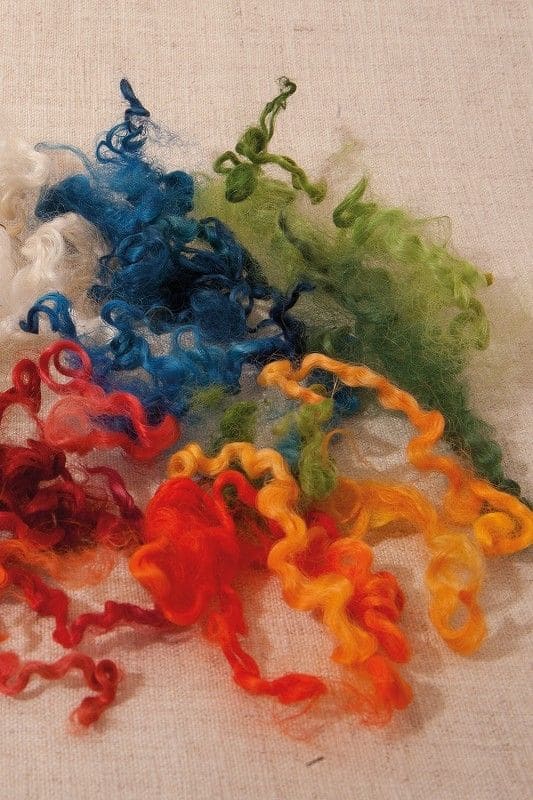 bunte Wolllocken auf beigem Untergrund