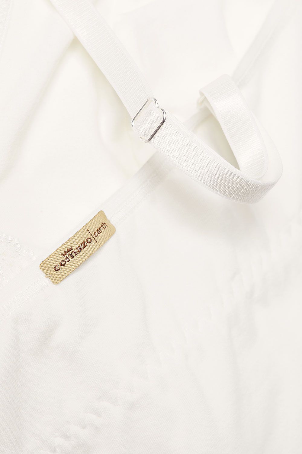 Detailftoto vom Etikett des naturweißen Spitzentops mit integriertem BH aus bio Baumwolle (kbA) und Elasthan