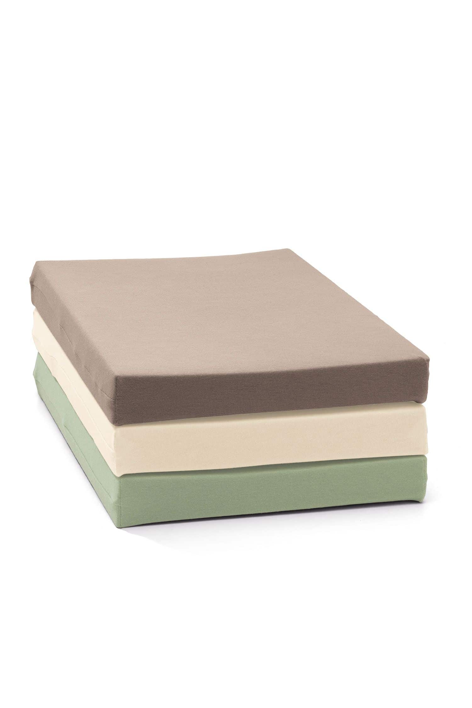 Spannbetttuch Gefaltete Spannbetttücher aus bio Baumwolle (kbA) in verschiedenen Farben gestapelt