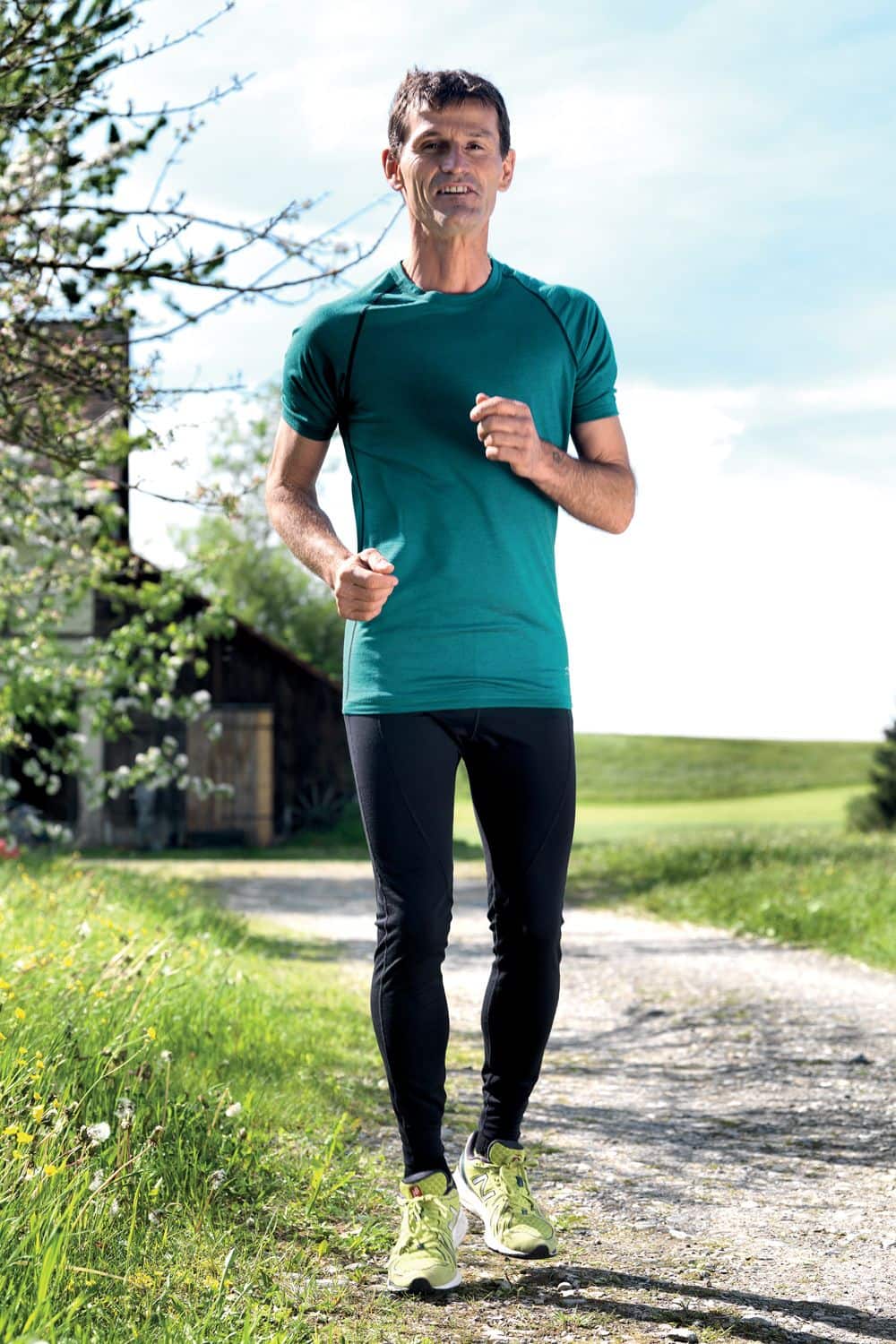 lange schwarze Herren Laufhose aus bio Wolle (kbT), Seide und Elasthan, getragen mit Shirt und Laufschuhen auf Feldweg