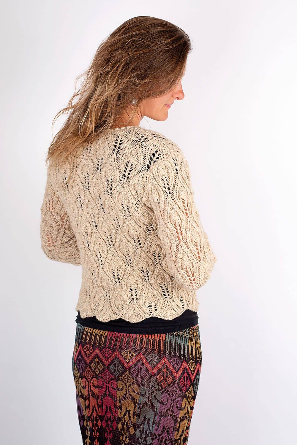 Strickweste als Produktbeispiel für dünne ungefärbte Fuchswolle vom Finkhof an Frau mit gemustertem Rock von hinten