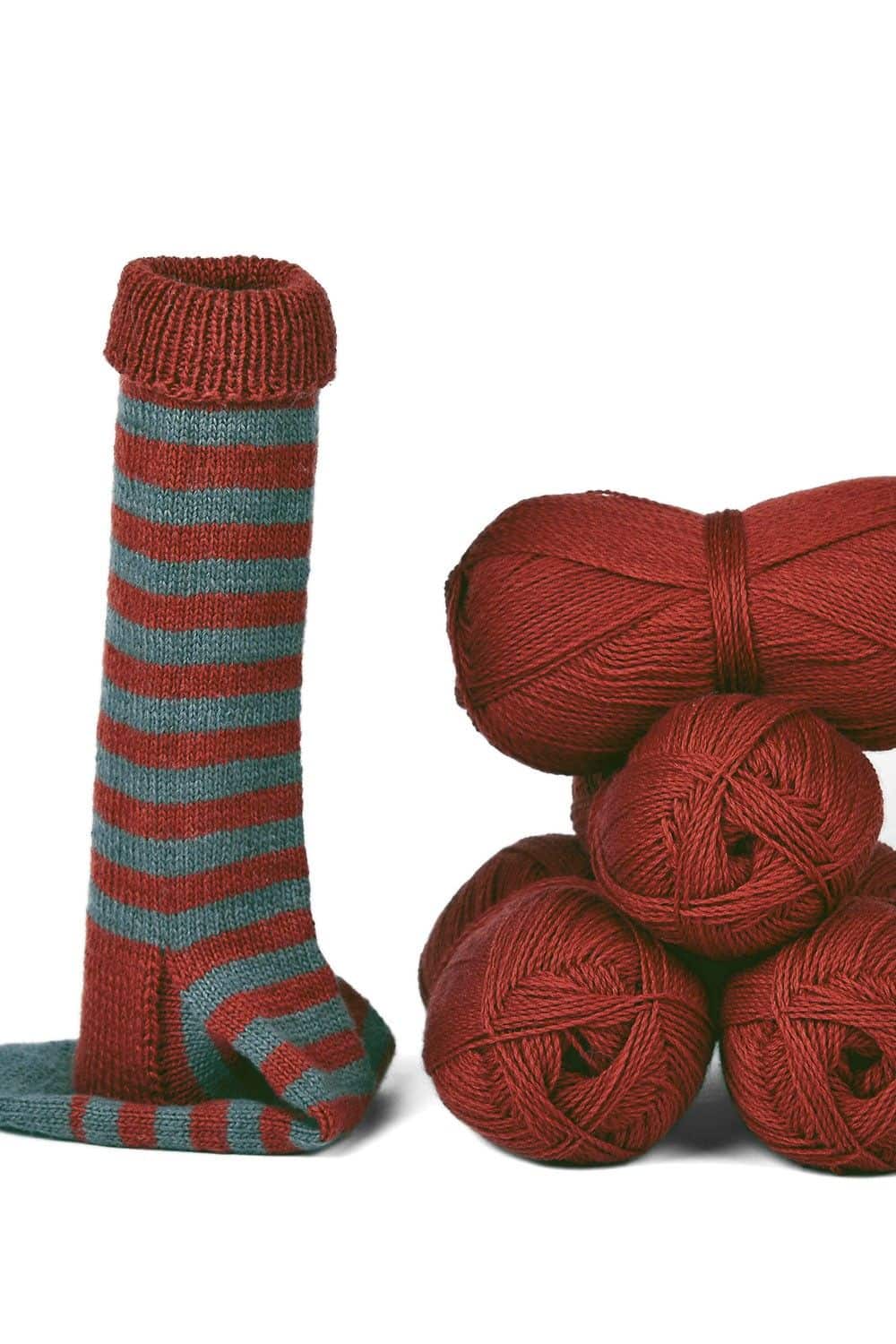 rostrote feine Sockenwolle vom Finkhof aus bio Wolle (kbT) mit Knäulen und fertiger Socke