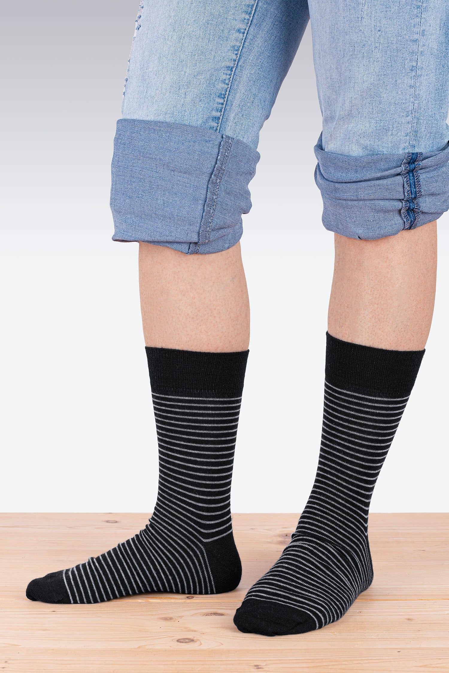 Person trägt schwarz graue feine Ringelsocken aus bio Wolle (kbT), bio Baumwolle (kbA) und Elasthan vom Finkhof
