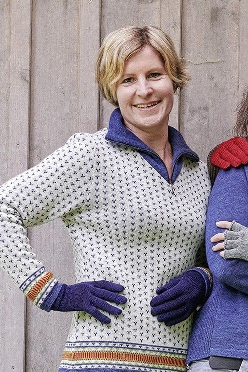 Frau mit weiß gemustertem Shirt trägt marineblaue Handschuhe mit Fingern aus bio Wolle (kbT) vom Finkhof