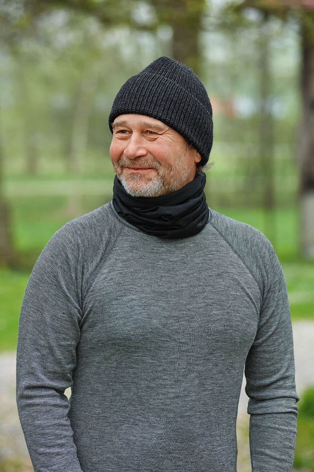 Mann mit grauem Shirt trägt schwarze Mütze und schwarzen Sportschal aus bio Wolle (kbT) und Seide