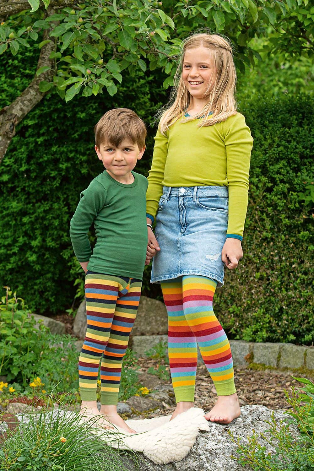 Kinder-Leggings Kinder im Garten tragen bunt gestreifte Leggings aus bio Baumwolle (kbA) und Elasthan mit einfarbigen Langarmshirts