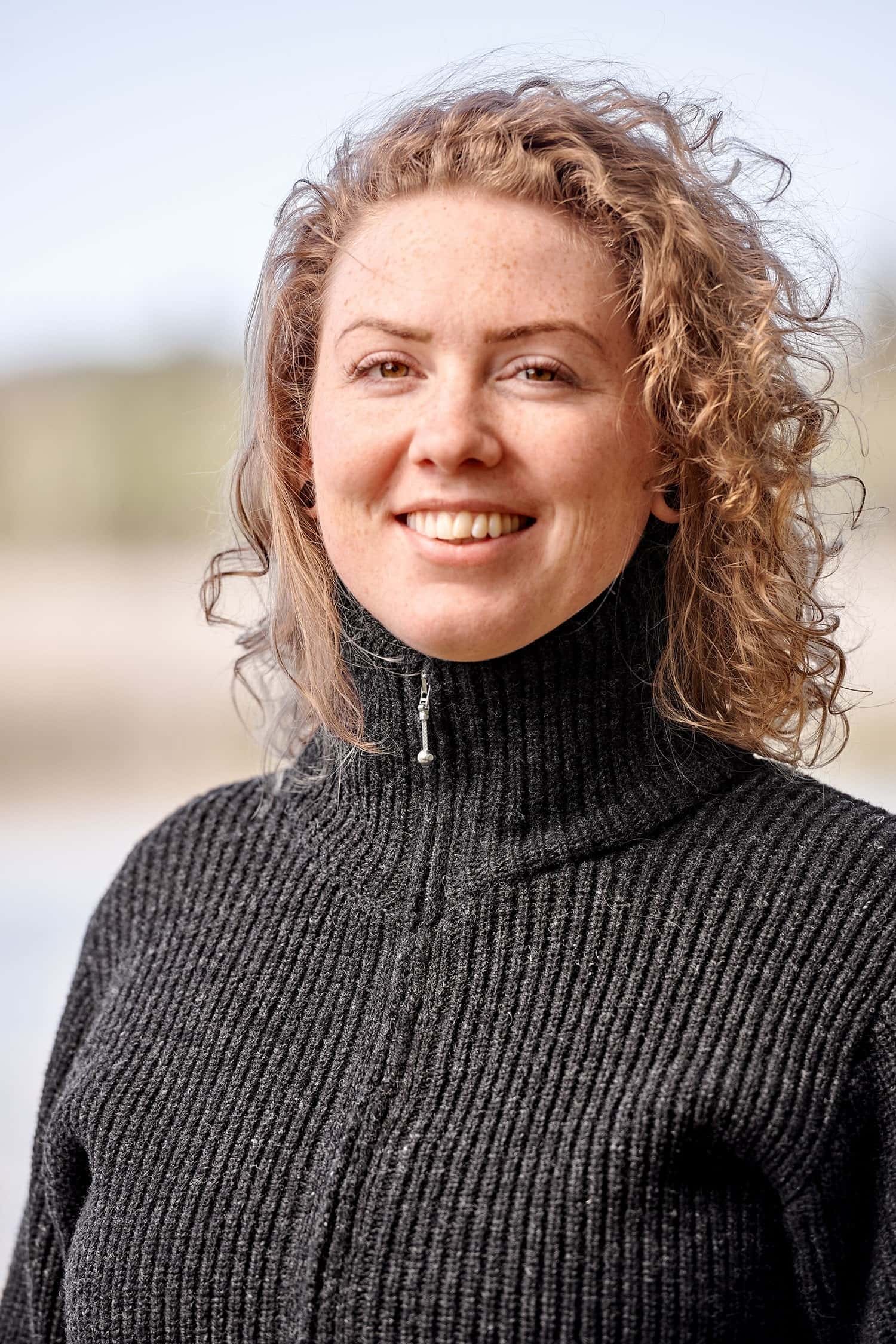 Portraitaufnahme von Frau mit dunkelgrauer Strickjacke aus Bio-Wolle mit Reißverschluss vom Finkhof